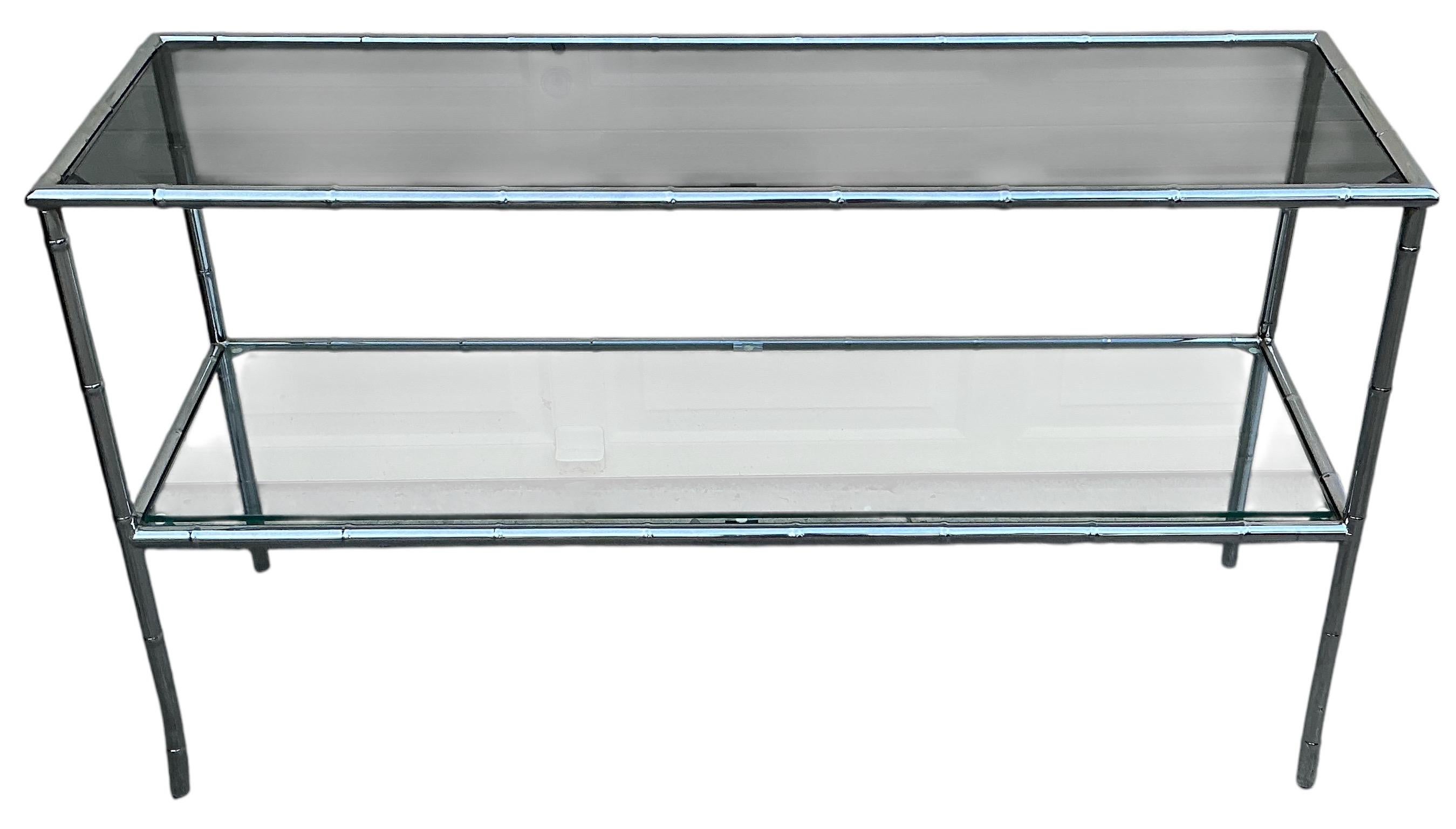 Dies ist ein 1970er Jahre moderne Chrom faux Bambus Konsole Tisch. Ein Regal ist aus Rauchglas, das andere aus Klarglas. Sie sind austauschbar. Vom Boden bis zum untersten Regalboden sind es fünfzehn Zentimeter. Es ist in sehr gutem Zustand.