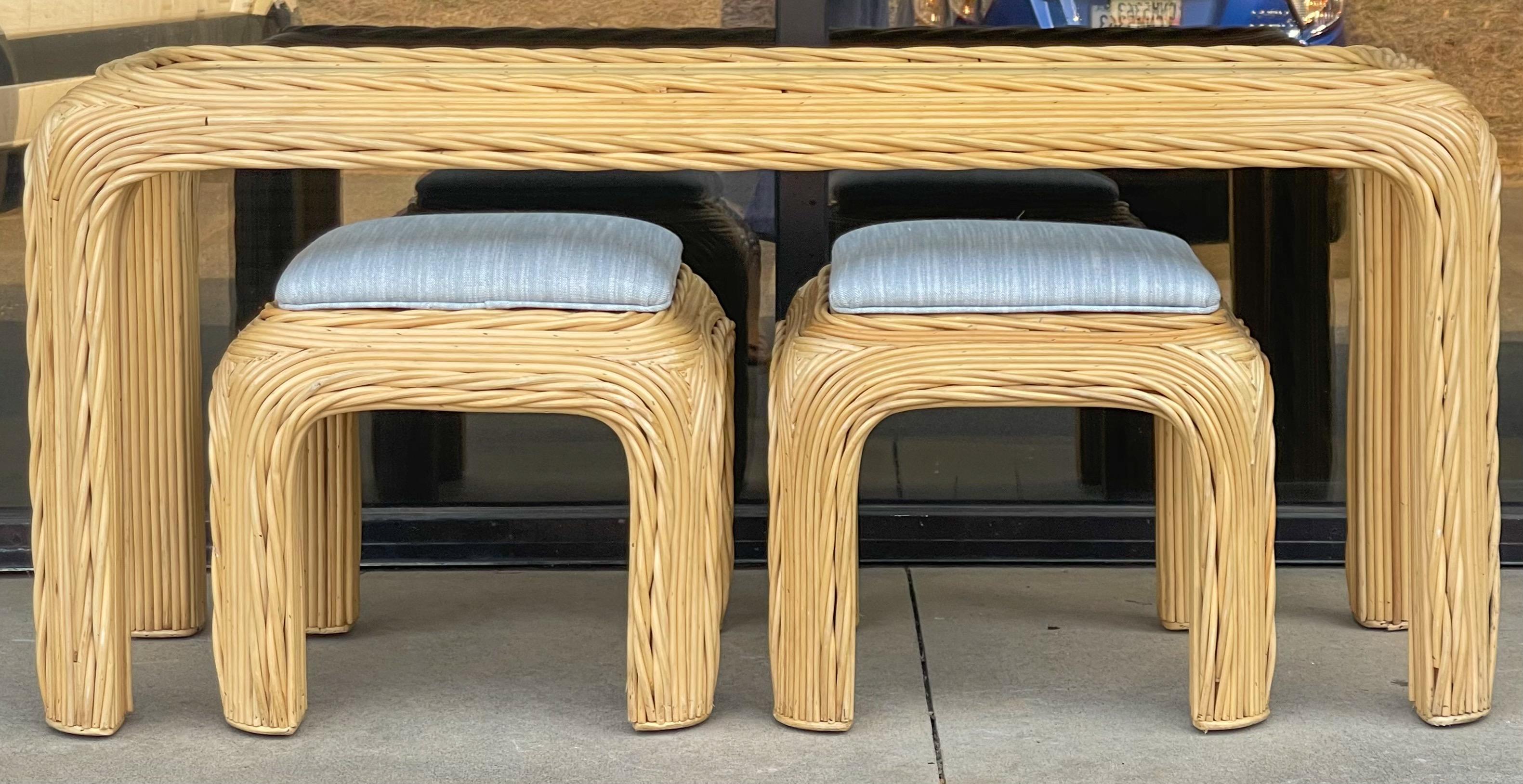 This is a pencil bamboo console table with two matching ottomans. The table has a removable glass top. The ottomans have new upholstery in a linen blend. The set has a fresh modern look! Stools: 18”L x 18”W x 17.5”H.