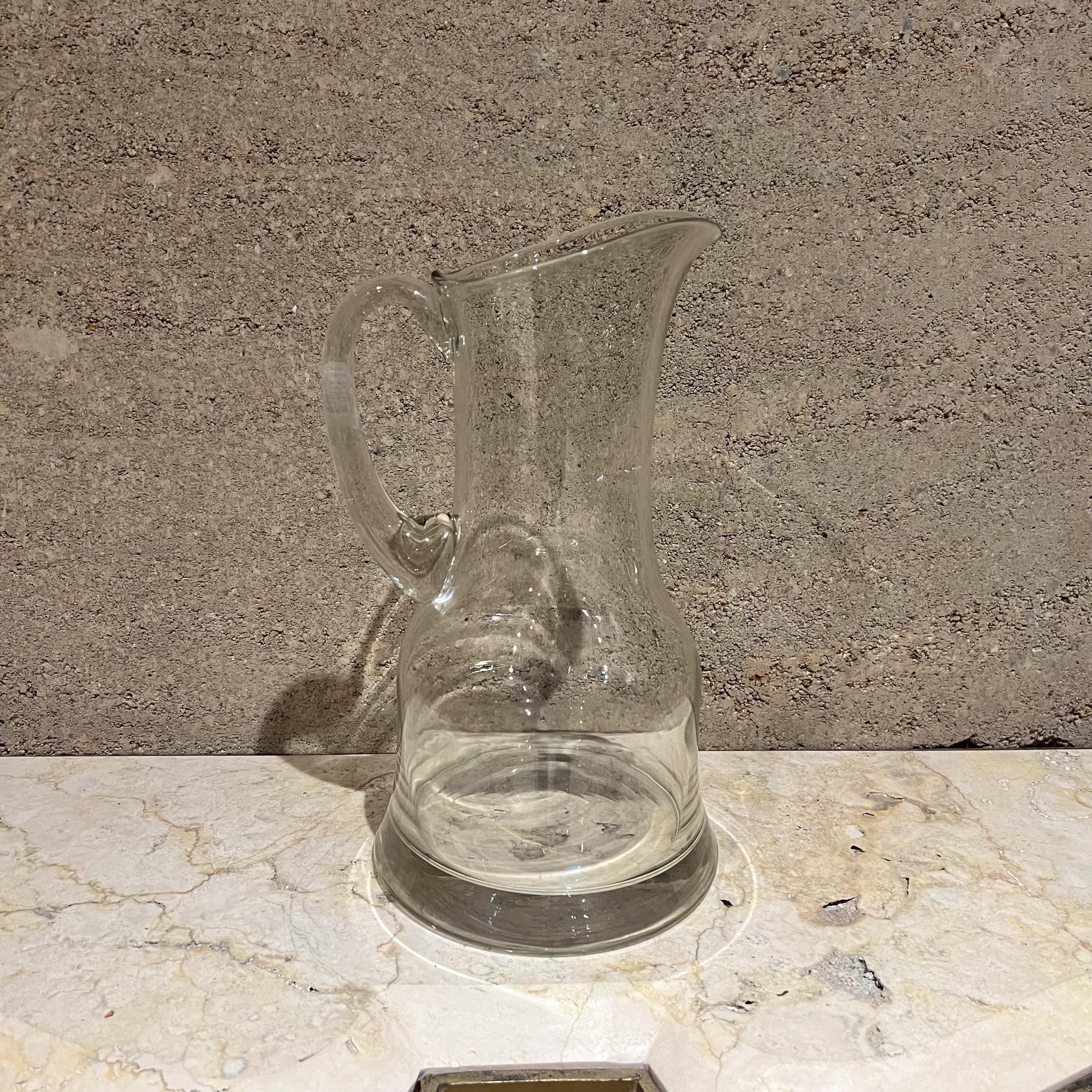 AMBIANIC Presents: a 1970s Glass Drink Pitcher 
modern lines. 
11.5 h x 6.75 diameter x 6.75d
Preowned vintage
Refer to images listed