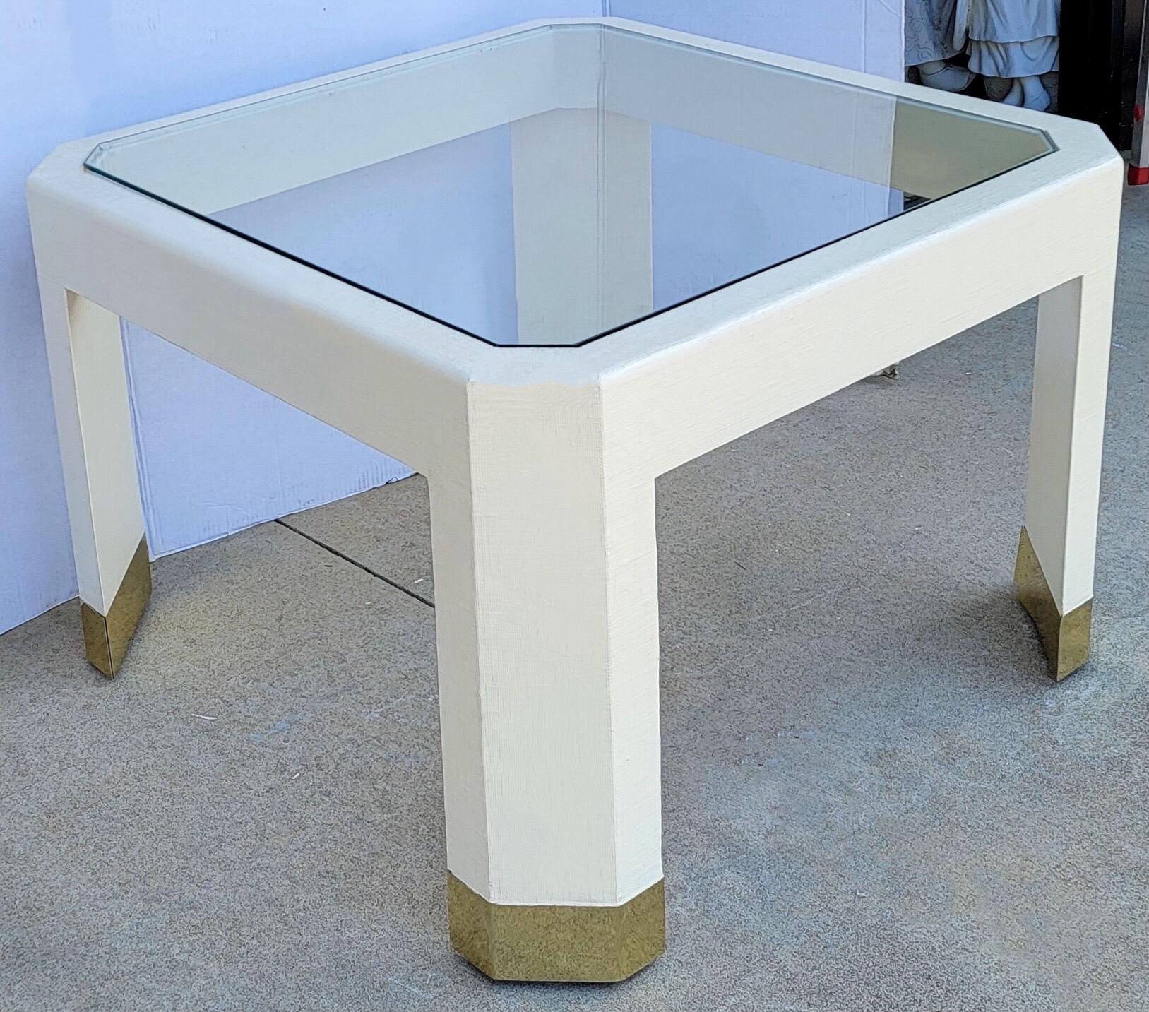 I love this! This is a modern glass top coffee table in the manner of Karl Springer. The frame is embossed in raffia. It is unmarked and in very good condition.