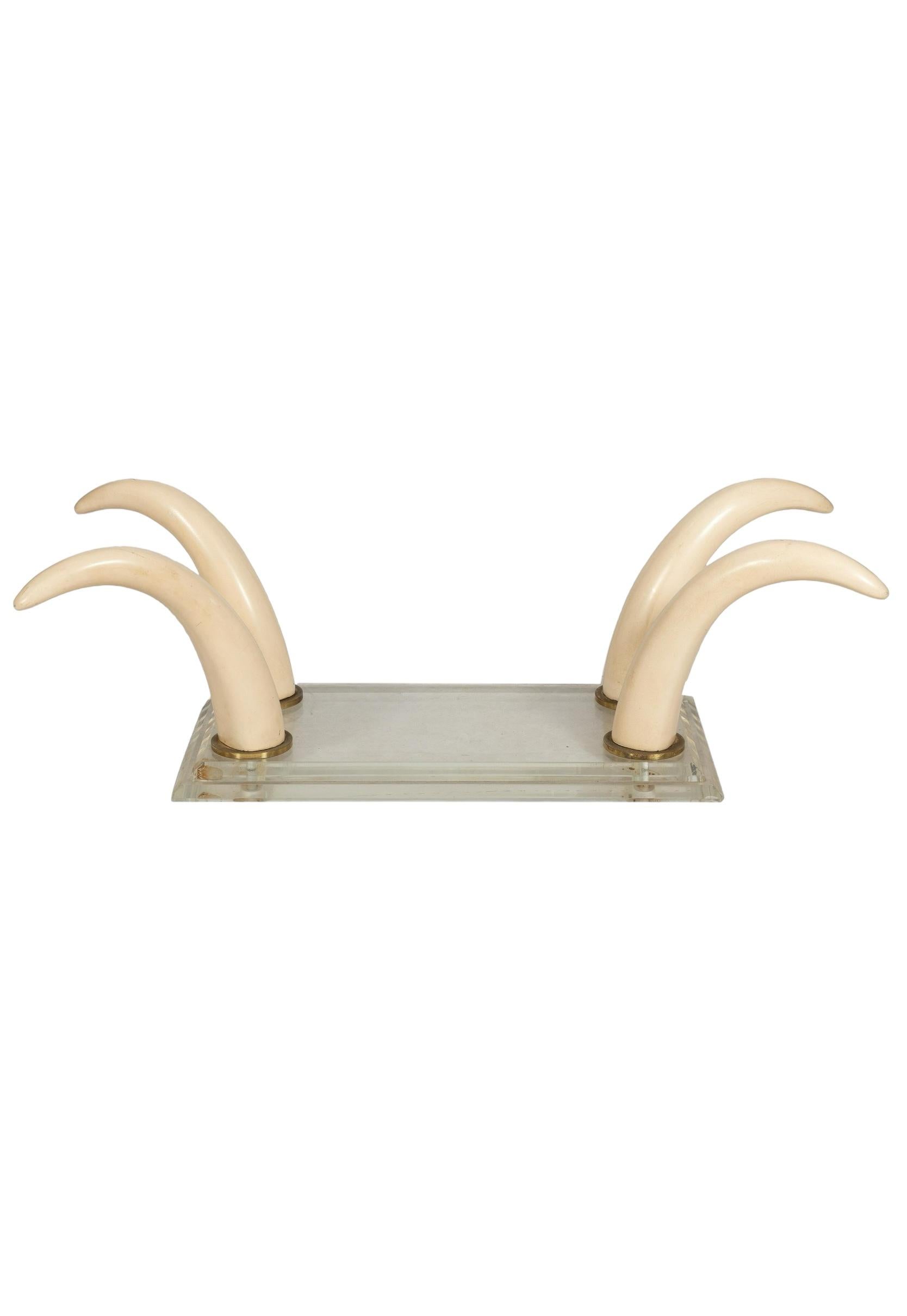 This is a 1970s modern Karl Springer style faux tusk and lucite coffee table with glass top. The tusks are resin and attached to a lucite base with bronze mounts. The piece is most likely by Spanish designer Italo Valenti. 

My shipping is for the