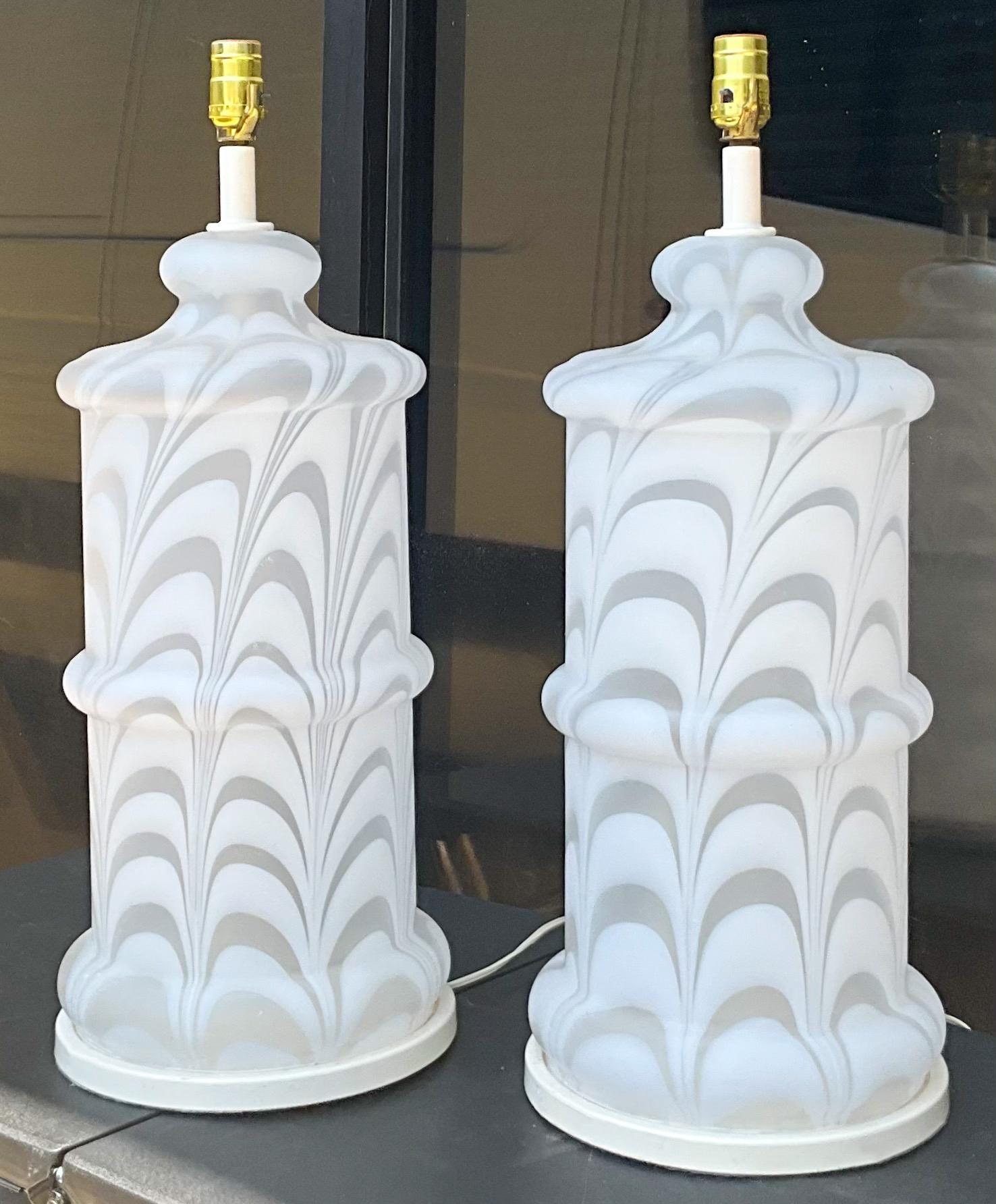 I love these! It is a pair of 1970s monumental modern Mazzega style swirled Murano glass table lamps. The bases are an enameled metal. They are in working order and very good condition. 