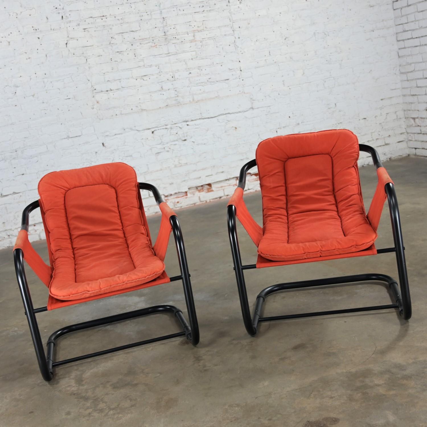Incredible vintage Modern orange & black painted tube cantilever sling lounge chairs in the style of Jerry Johnson, a pair. Beautiful condition, keeping in mind that these are vintage and not new so will have signs of use and wear even if it has
