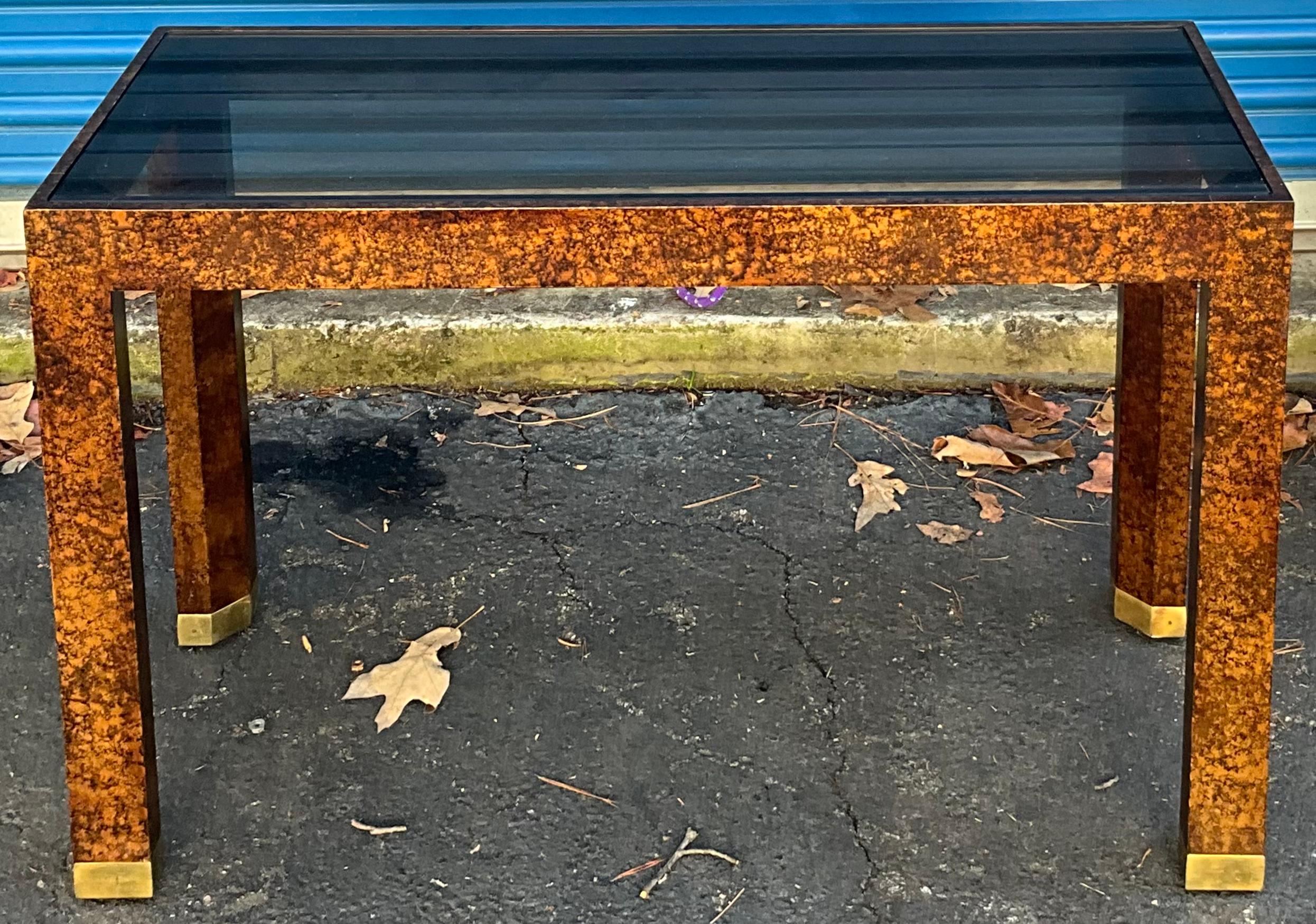 This is a good looking piece! It is a faux tortoise Parsons style console table with glass top and brass capped feet. It is in very good condition and unmarked.