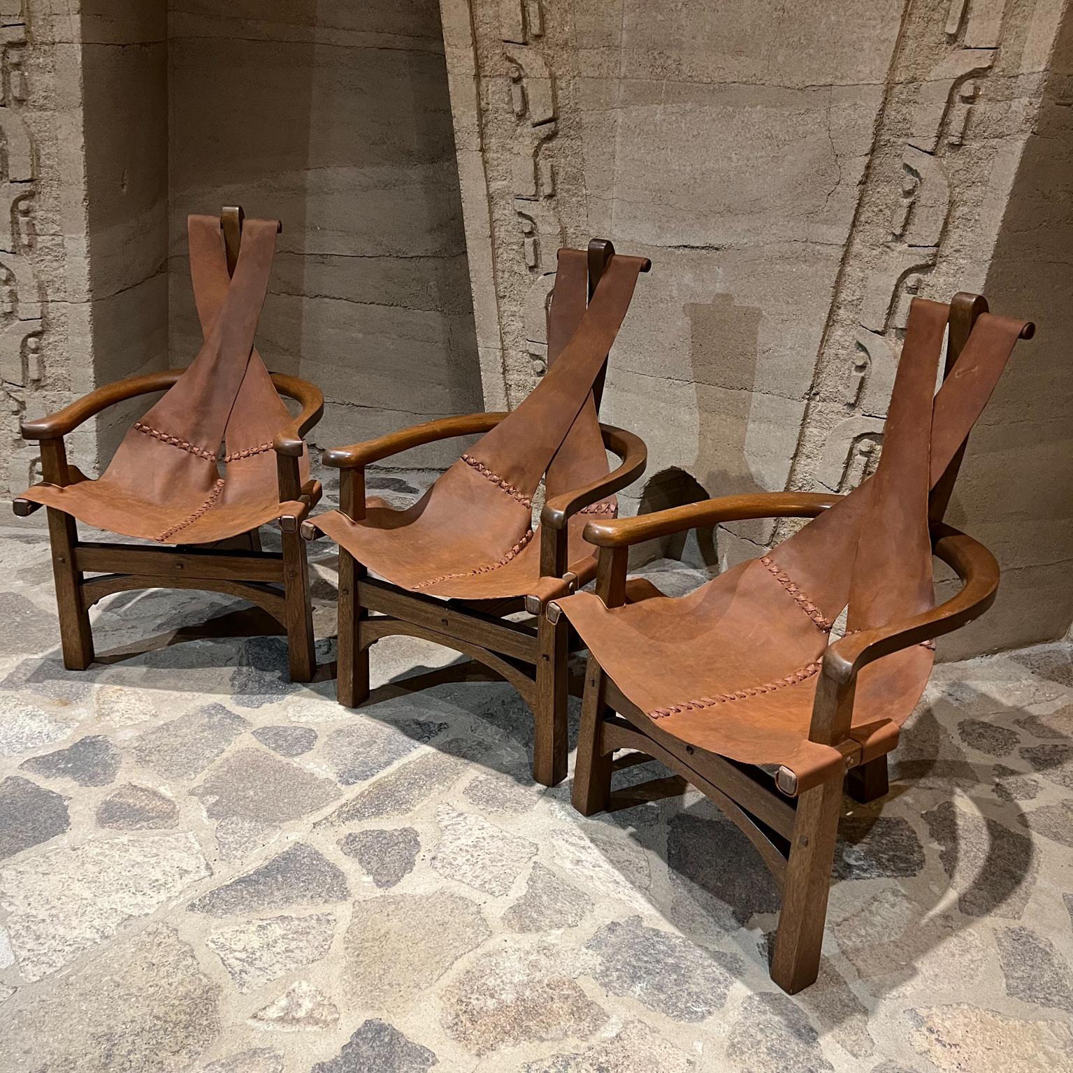 1970s Modern safari lounge set of three leather sling chairs on three-legged mahogany wood base
Brazilian style of Jean Gillon and Percival Lafer.
Unmarked.
Measures: 40 tall x 23 deep x 24 wide seat height 16.
Original preowned vintage