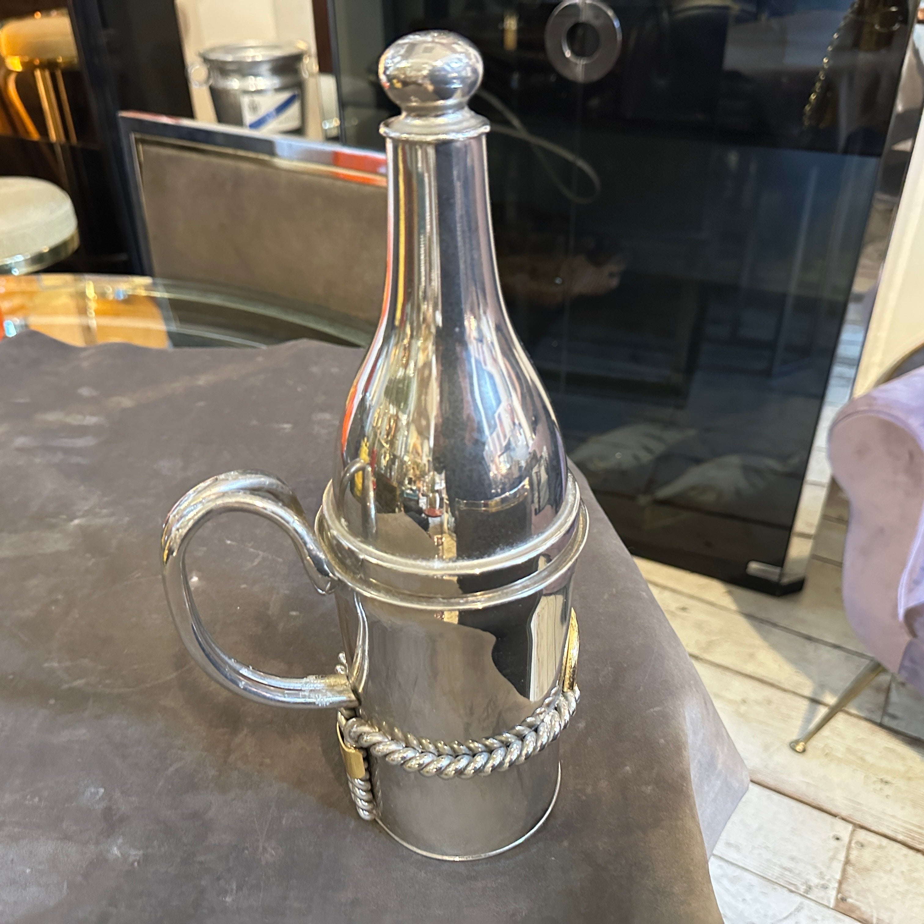 This 1970s Gucci bottle is a striking combination of luxury and functionality, showcasing the high-quality craftsmanship the brand is known for. The body is silver-plated, giving it a polished and reflective finish, while the gold accents provide a