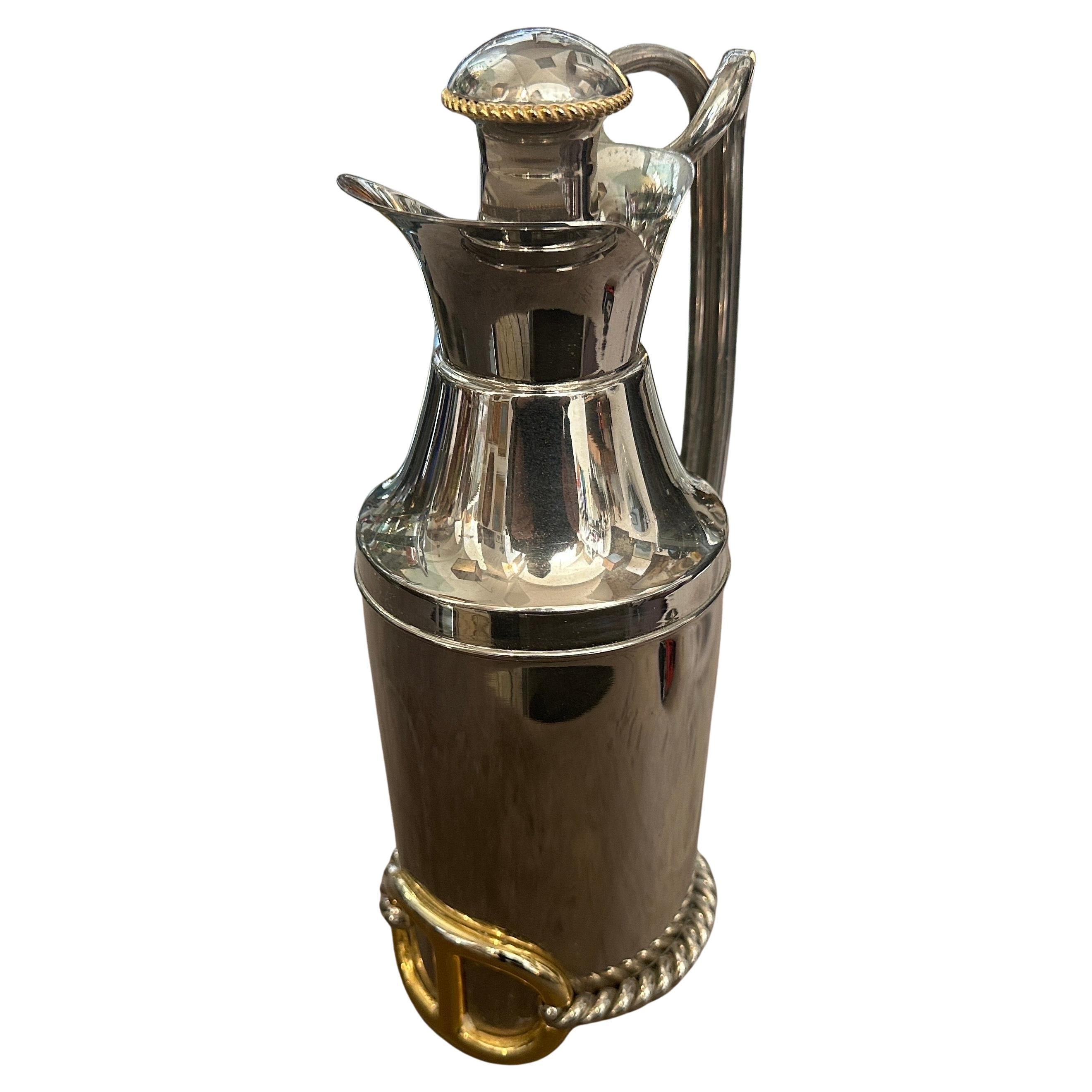 This 1970s Gucci thermos carafe is a striking combination of luxury and functionality, showcasing the high-quality craftsmanship the brand is known for. The body is silver-plated, giving it a polished and reflective finish, while the gold accents