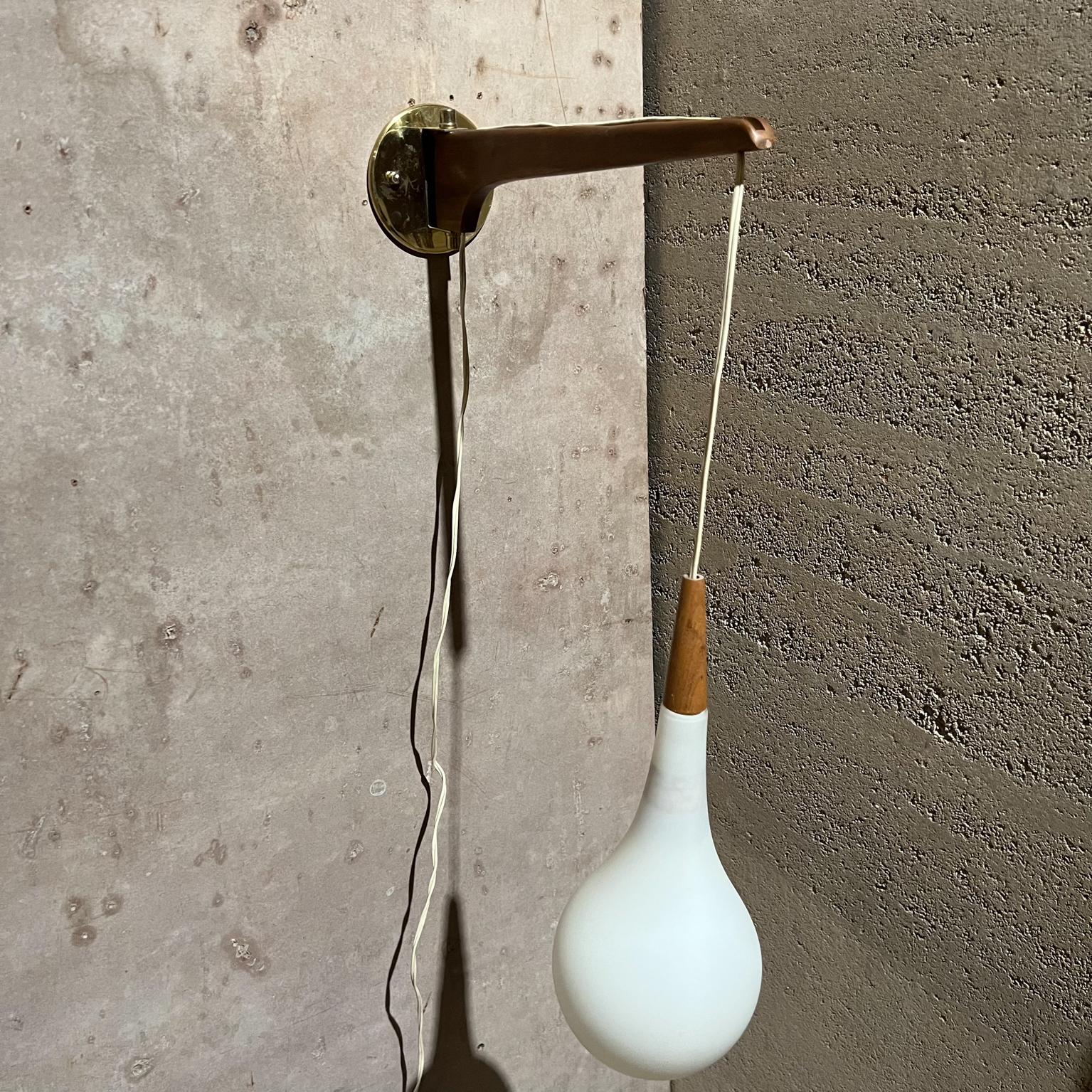 1970s Modern wall sconce pendant light Scandinavian Teakwood & Frosted Glass
Unmarked, in the style of Finnish Lisa Johansson-Pape.
Adjustable height and swiveling angle.
16 d x 5 w x 14.5 h adjustable
Preowned original vintage condition, see
