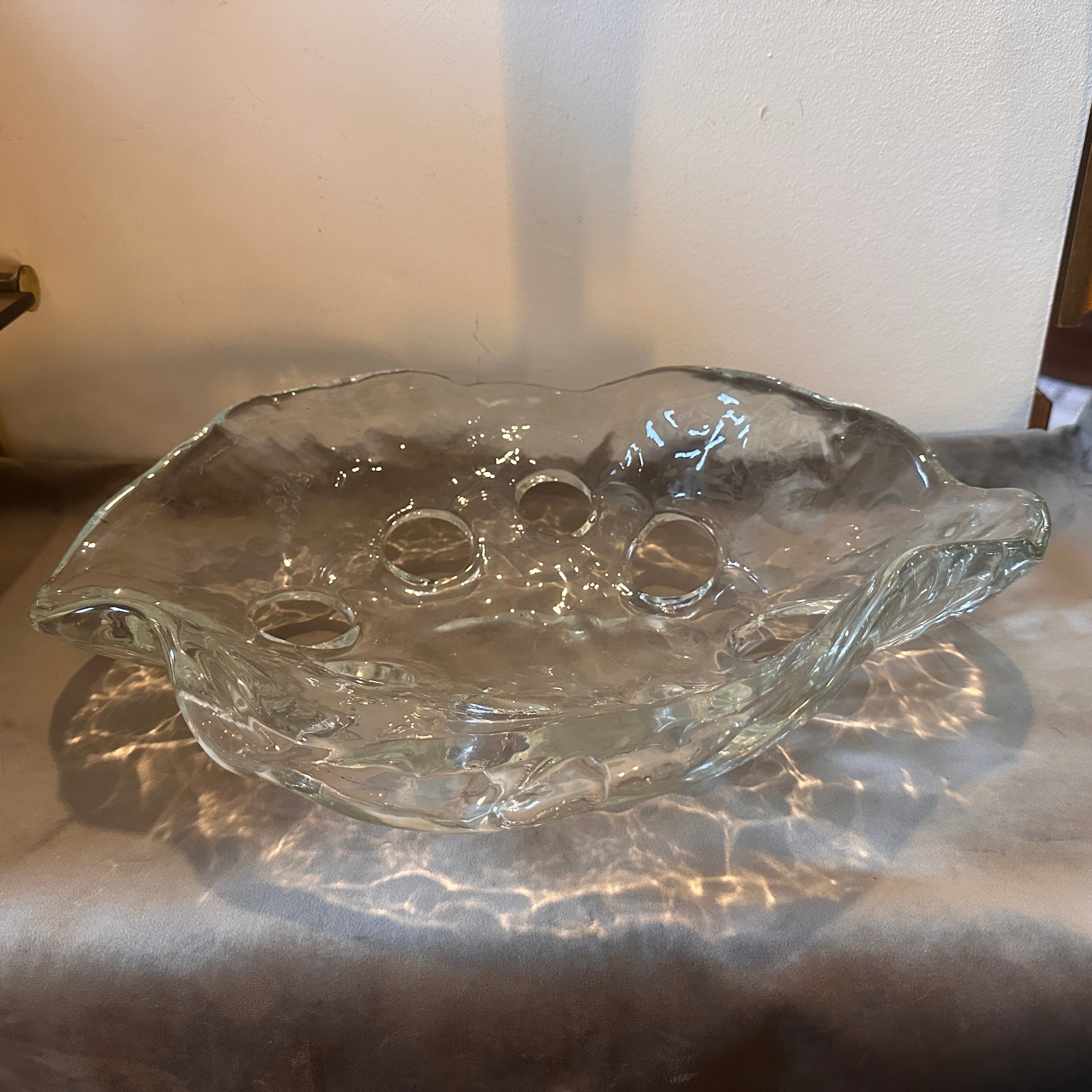 Ce centre de table ovale en verre de Murano, de style moderniste des années 1970, est un exemple exquis de l'artisanat italien, alliant fluidité du design et expression artistique.
Le centre de table a une forme ovale allongée, parfaite pour un