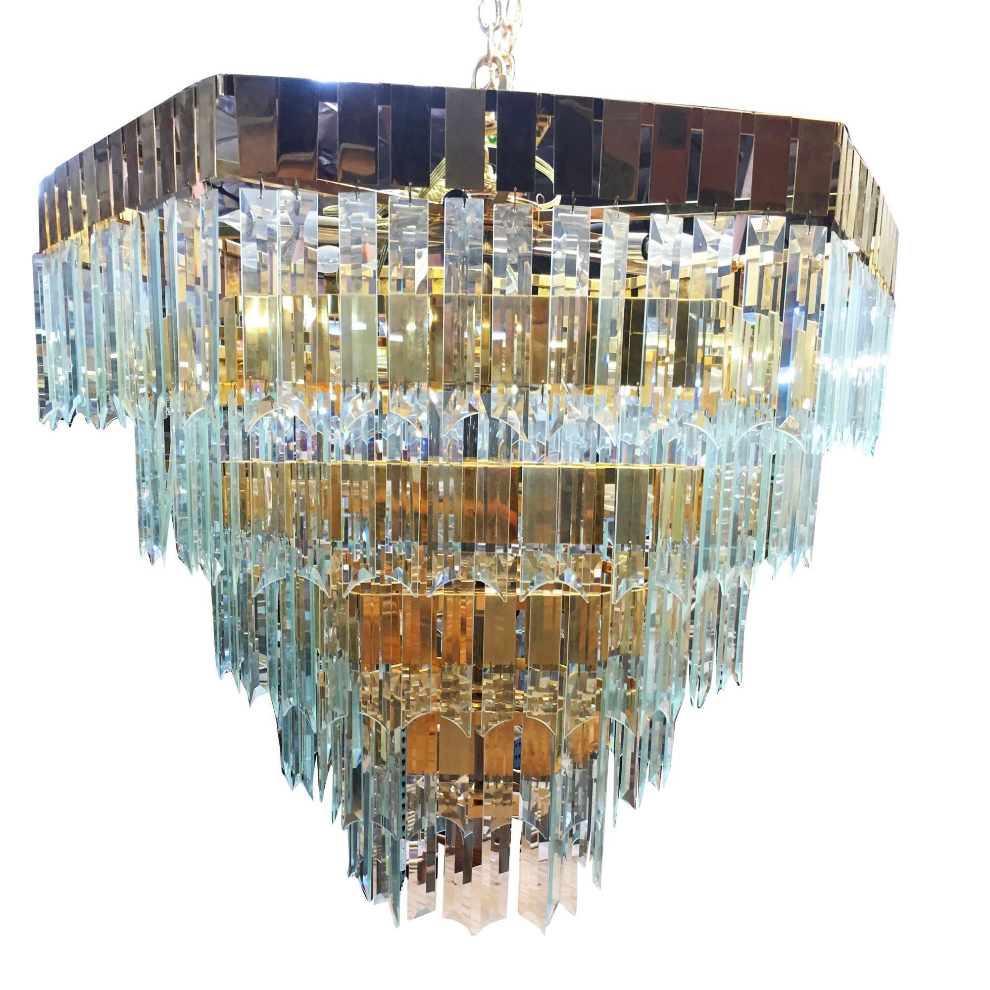 Modernist hanging crystal brass chandelier featuring a 5-level brass framed chandelier holding over 300 cut crystal pieces of crystal, circa 1970s. Each crystal piece is connected to a flat brass hook which easily hangs on the chandelier frame. The