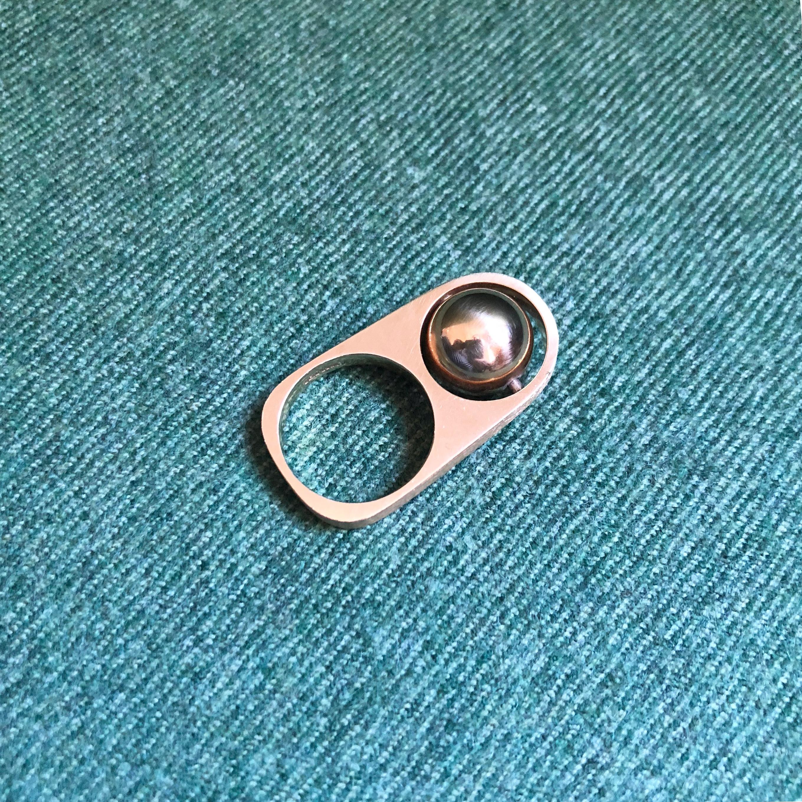 A 14 karat rotating ball gold ring, by Hans Hansen, c. 1970. The ring is size 5.5. It is samples HH. 585. Denmark. It measures 1.25