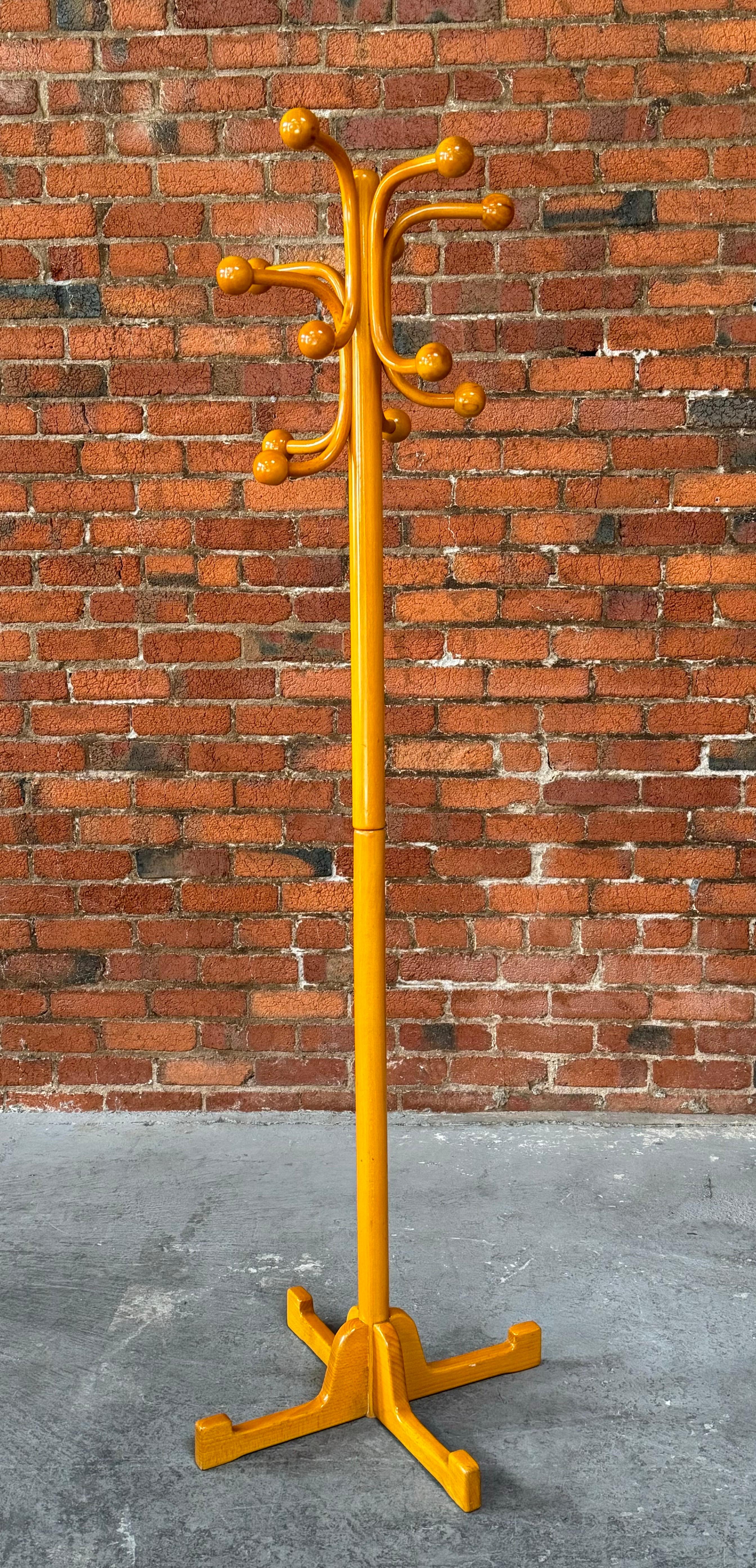 1970s modernist Italian coat rack in a honey colored lacquered birch. Multiple spheres on various branches to hold hats and coats with a wide base for stability. A very architectural form that fits in any decor.  The rack is designed to come apart