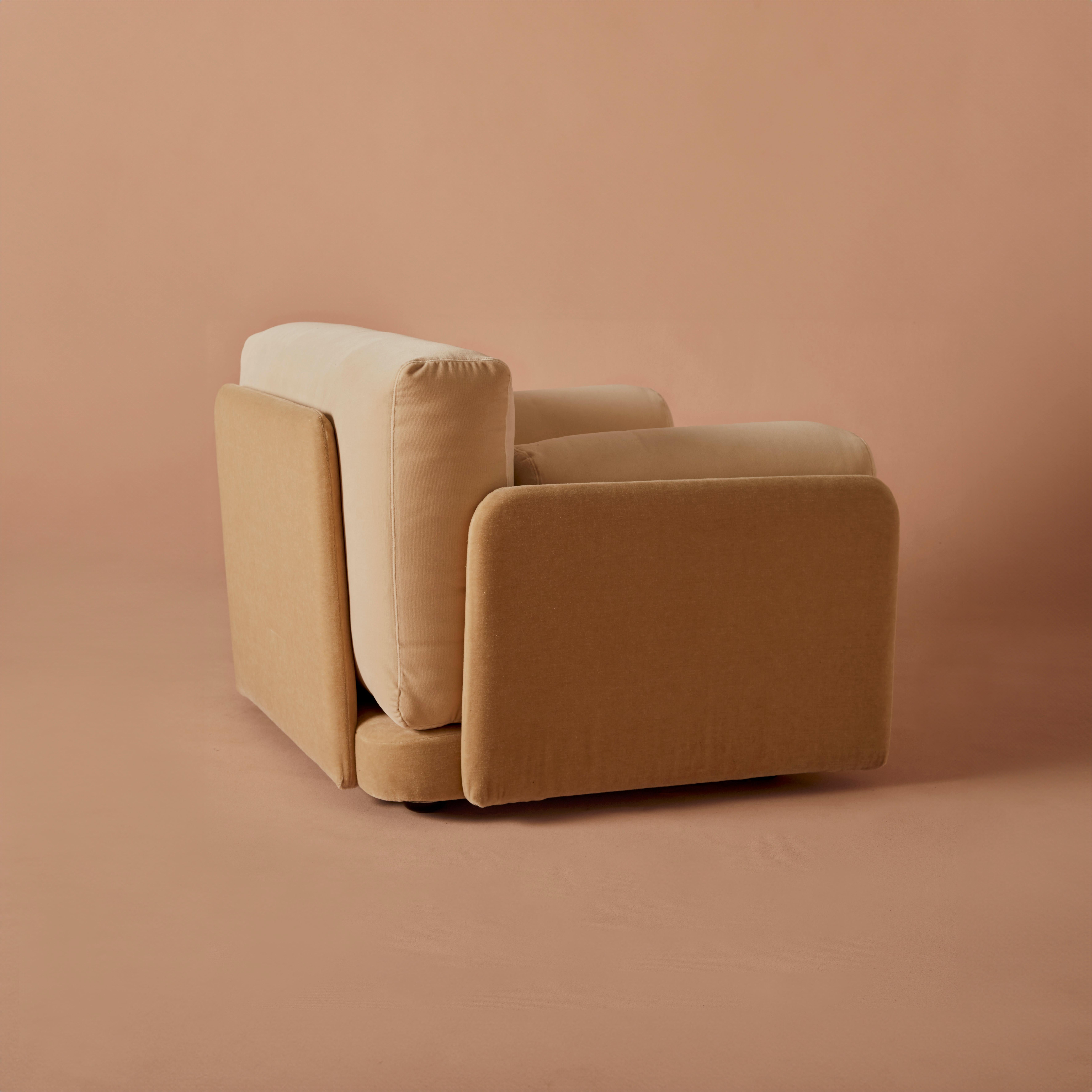 Soft-structured foam forms the seat of the chair, supported by rigid wooden supports. 
Upholstered in two tonal velvets of different textures, these sizeable armchairs are interesting from every angle, the mohair velvet catching the light
