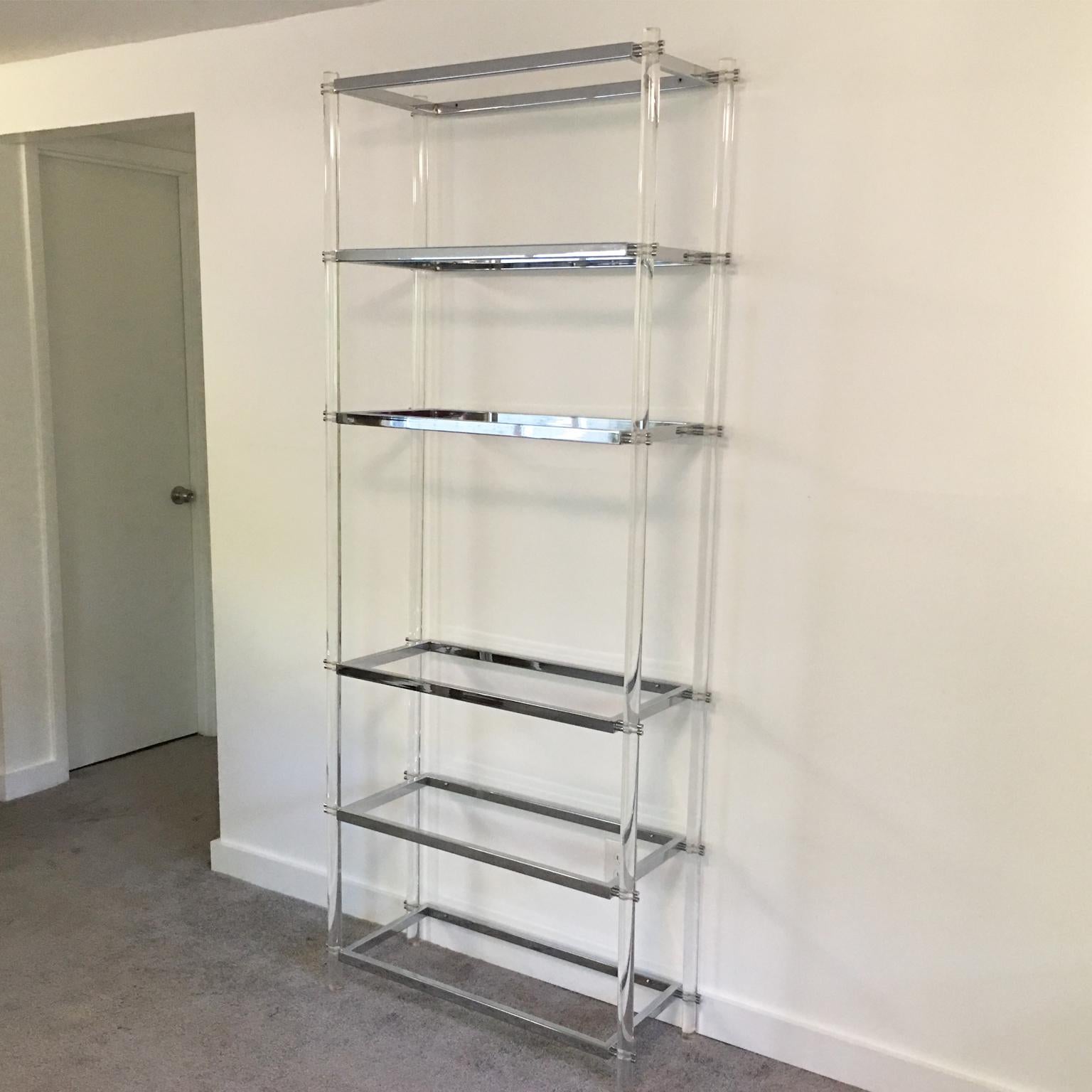 Striking 1970s modernist display shelf makes an ideal storage piece for a large variety of interiors. This elegant étagère or bookcase is sculpturally designed with crystal clear Lucite thick rods and chromed metal framing and accented with six