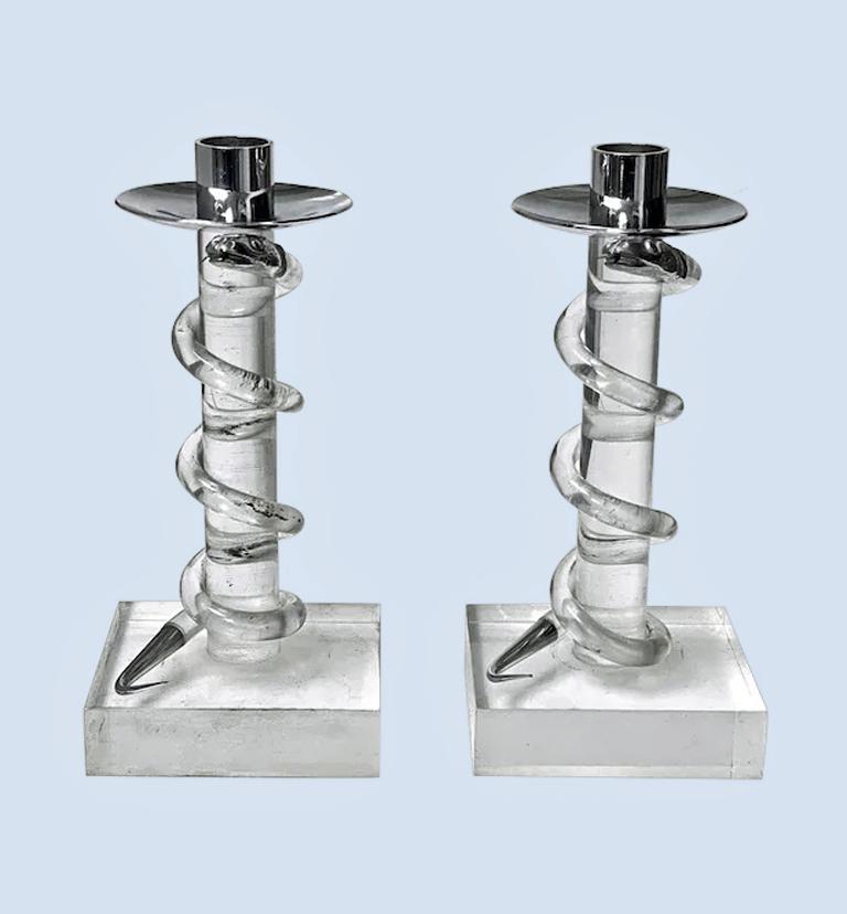 A pair of striking Modernist mixed media metal and Lucite candlestick holders, probably designed circa 1970 by Alessandro Albrizzi (Italian, 1934-1994). Holders having acrylic bodies with square bases surmounted by wide rimmed chrome holder cups.