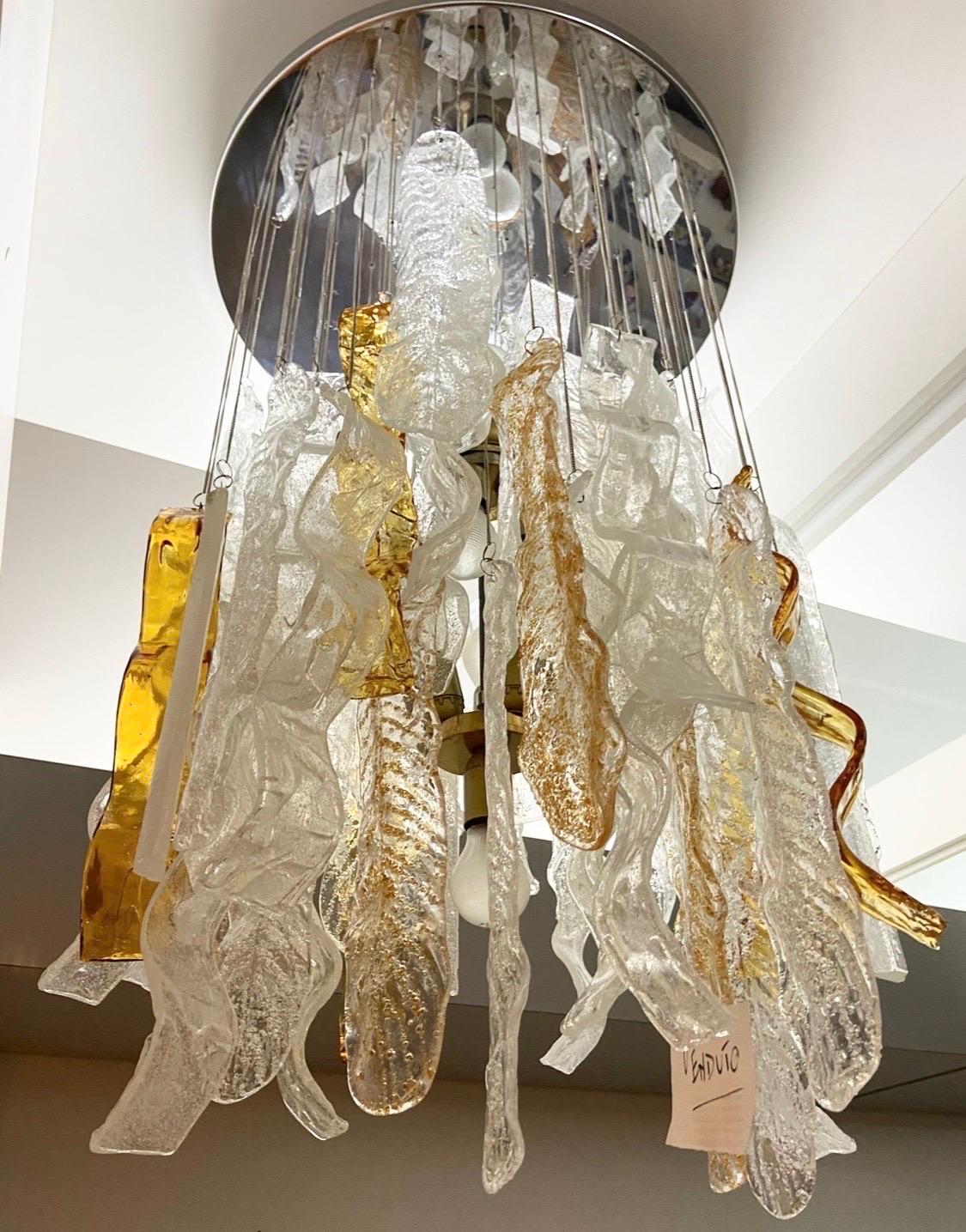 A big white and brown Murano glass chandelier, designed and manufactured in the Seventies by Mazzega, features five different kinds of big Murano glass pendants, creating an amazing ambient light. The Murano glass elements are in very good