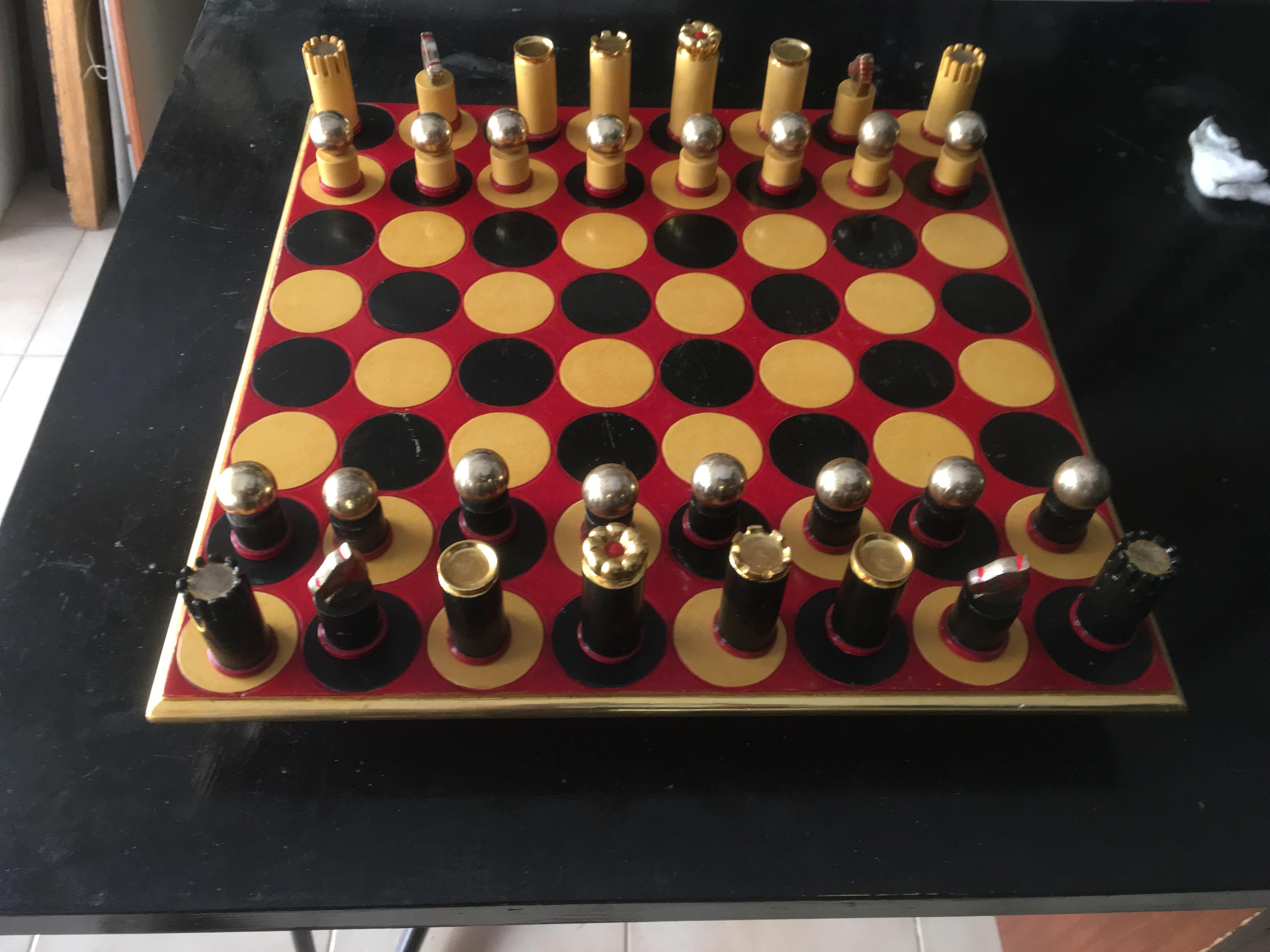 Vintage chess board in painted and gilded wood. The chessboard is very original, the chess is round and not square, painted in black and gold on a red background. The game pieces are modern and painted in black and gold.