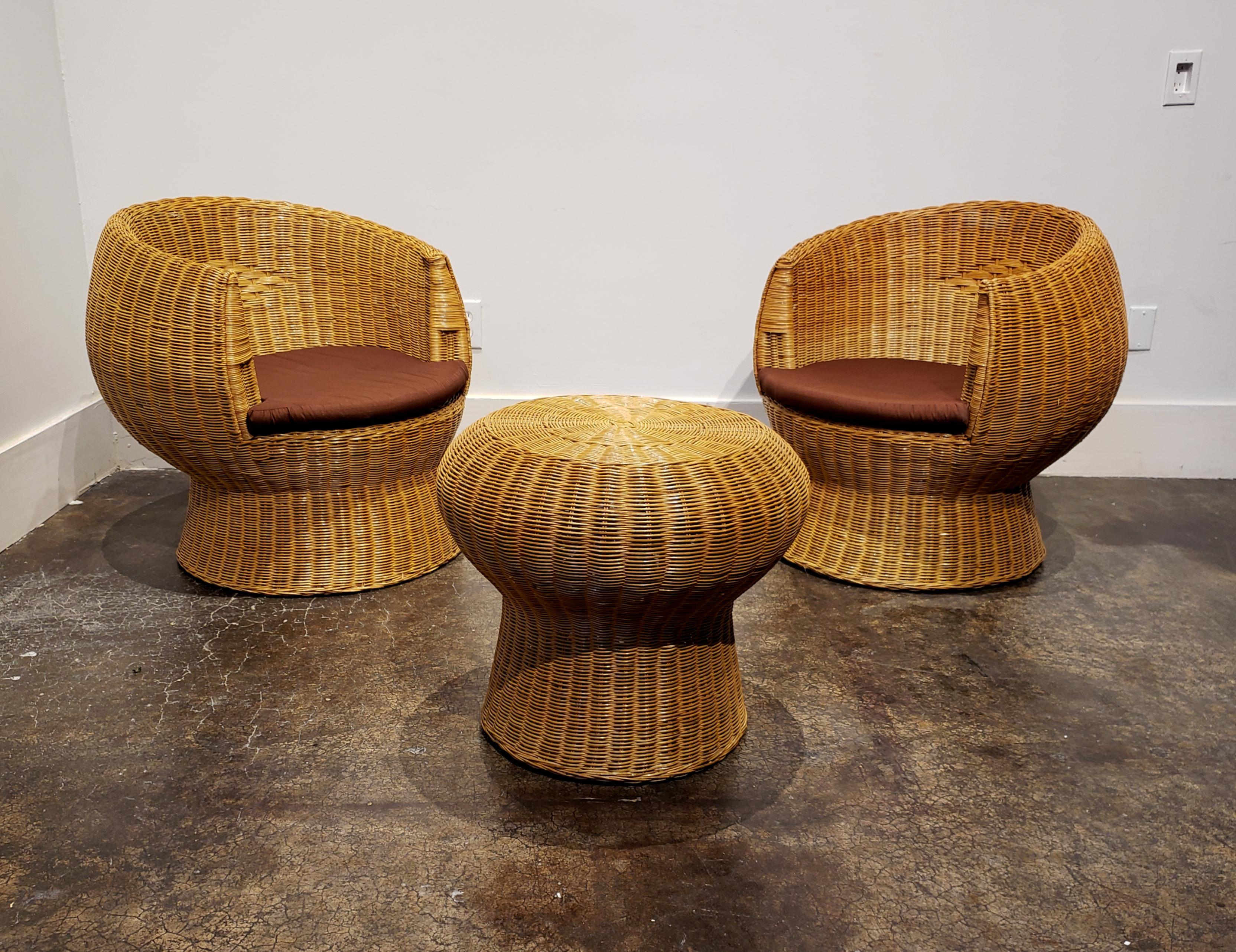 1970s modern patio wicker set with two chairs and one side table. Beautiful rounded shape typical of the 1960s and 1970s Space Age aesthetic. In very good condition with light wear.

Chairs are 29