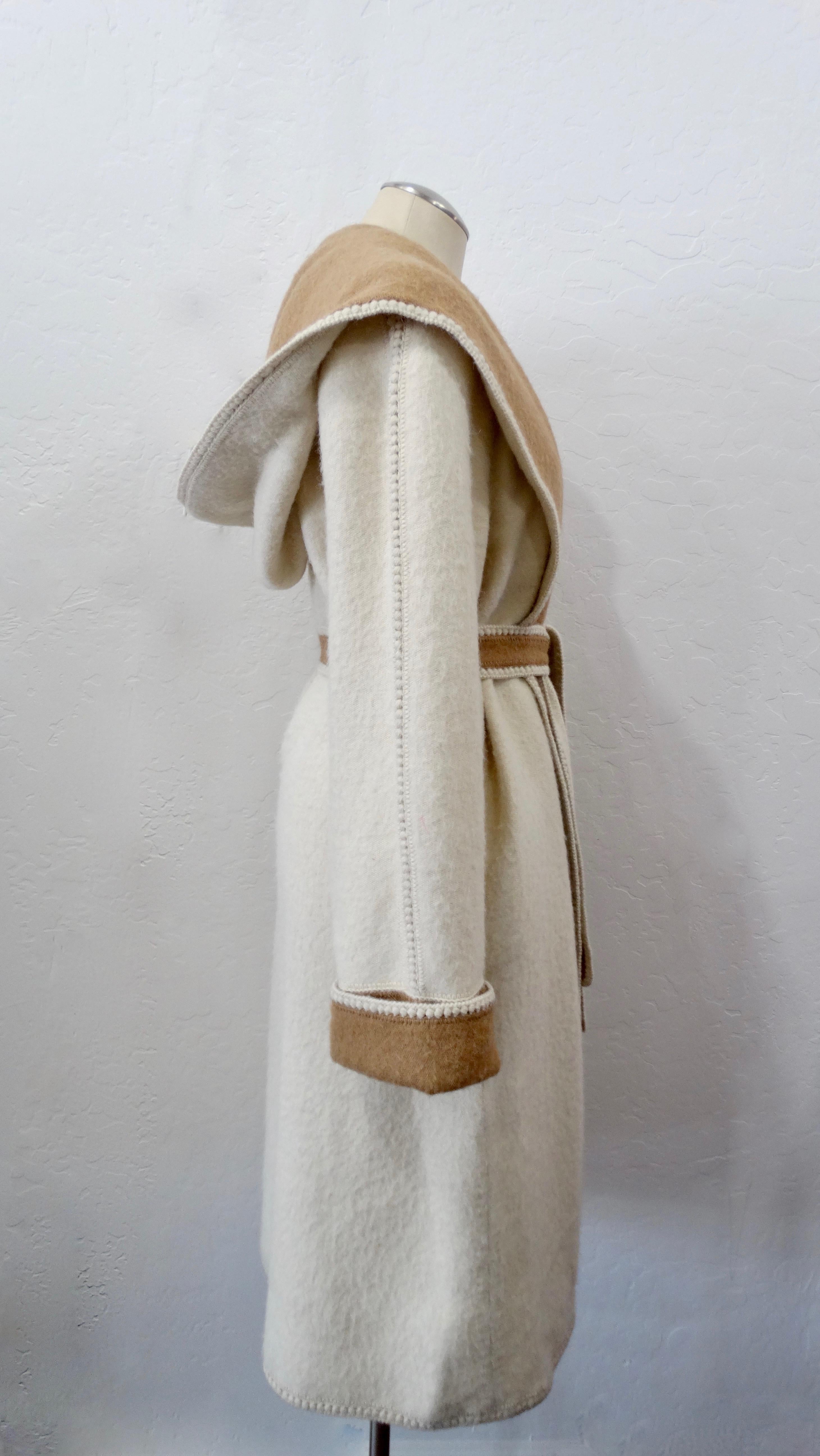 Keep it simple and chic this winter with this gorgeous Mon Repos coat! Circa 1970s, this coat is made of creme and camel colored alpaca wool. Features a decorative trim, long shawl collar, inseam pockets and an optional two-tone tie belt. Back of
