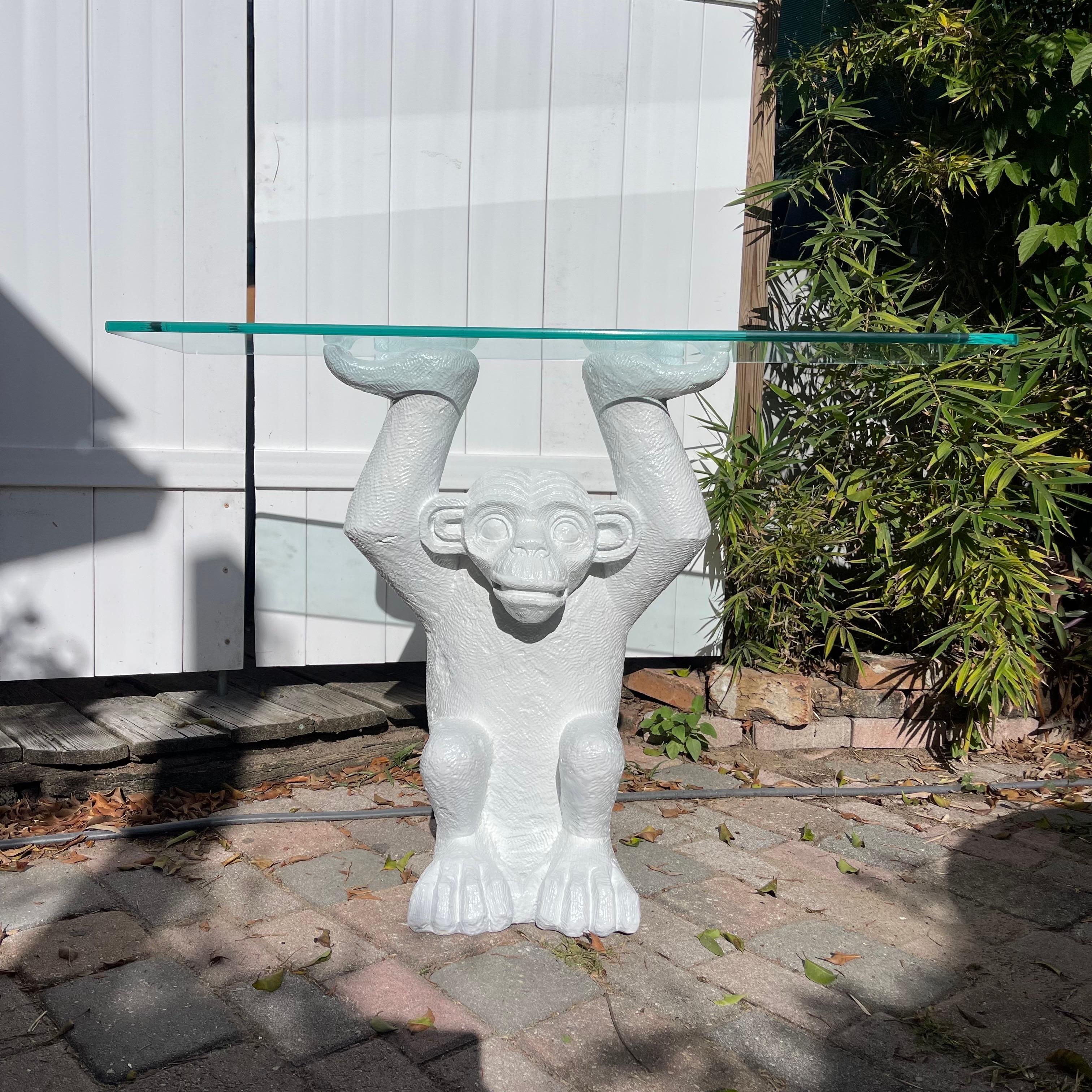 Console fantaisiste en forme de singe tenant un morceau de verre.