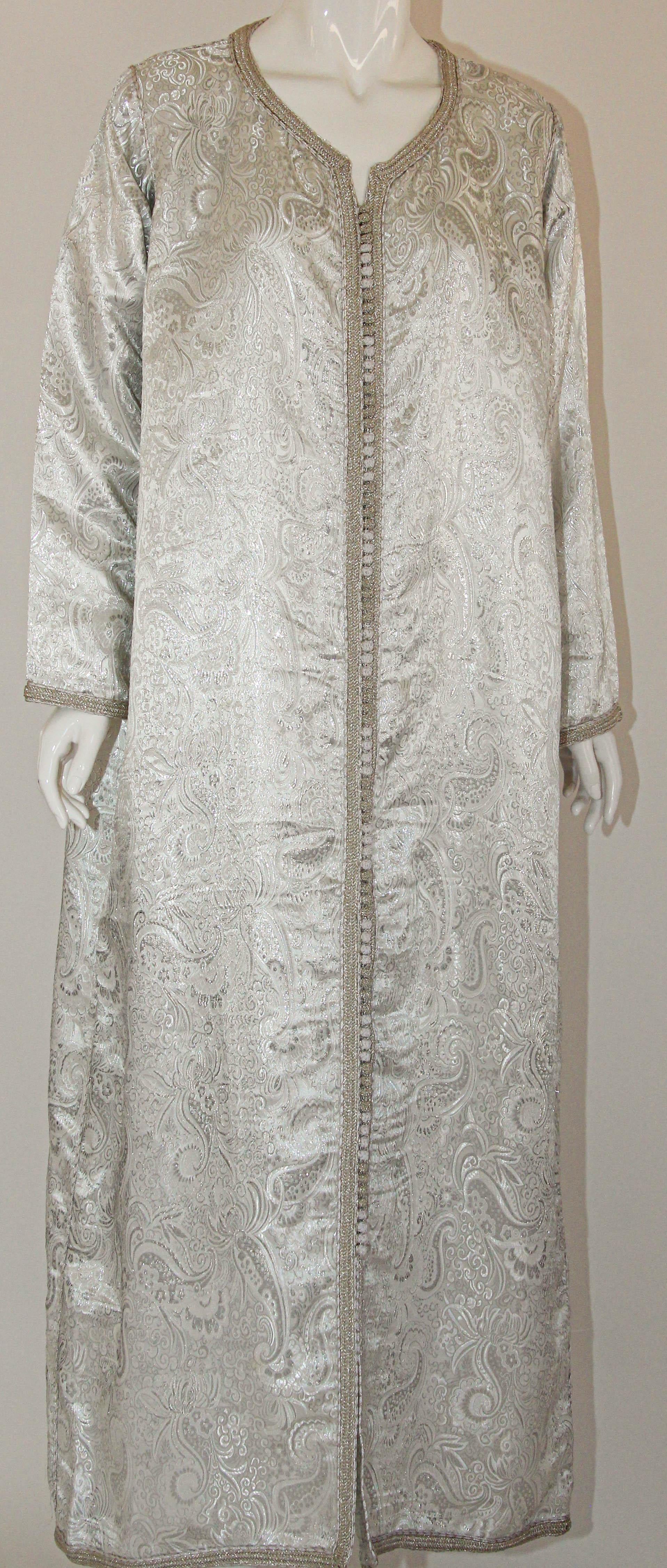 1970s Moroccan Vintage Caftan, Silver Damask Kaftan Bohemian Maxi Dress.
This 1970s Moroccan vintage caftan is a timeless and captivating piece of clothing that embodies the essence of Moroccan culture and style from that era.
This stunning caftan