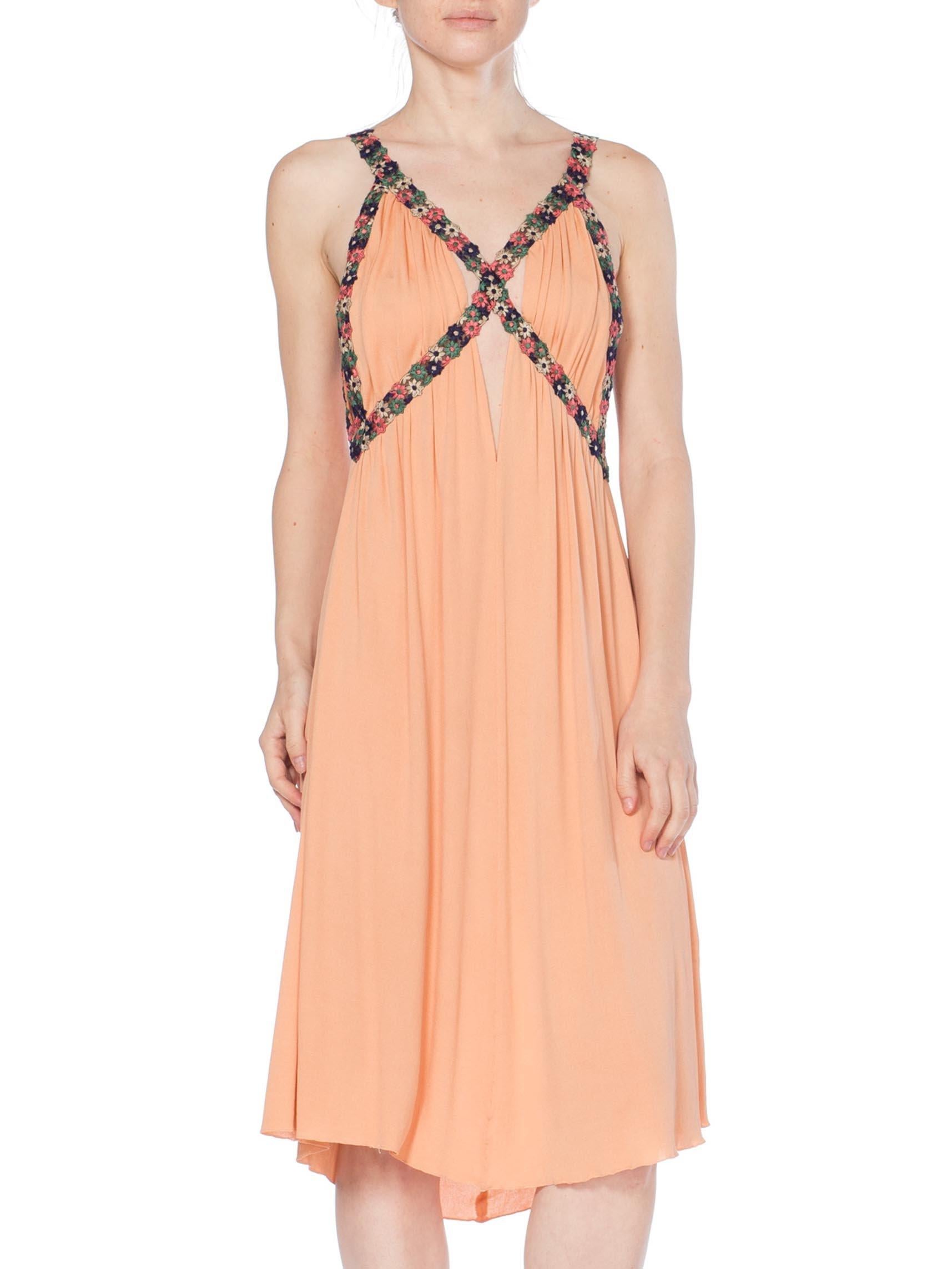 MORPHEW COLLECTION Peach Silk Jersey Dress With Cutout Front & 1930S Floral Trim
MORPHEW COLLECTION is made entirely by hand in our NYC Ateliér of rare antique materials sourced from around the globe. Our sustainable vintage materials represent over