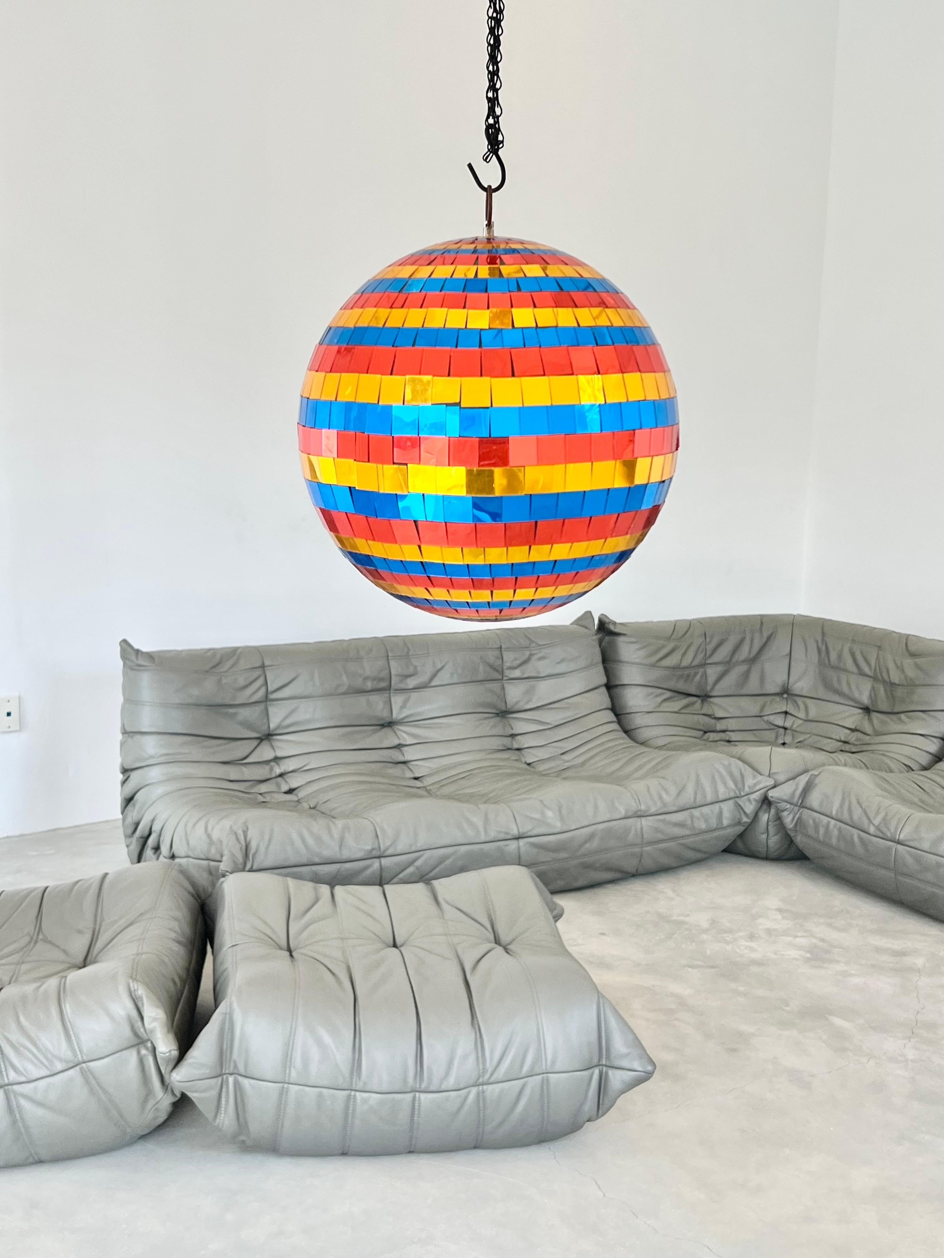 Unusual disco ball from the 1970s. Multi-color tiles with the classic mosaic pattern covering a disco ball. Foam center. Metal hardware. Great piece of art. Very good condition. Perfect piece of sculpture to hang from the ceiling. Approximately 12