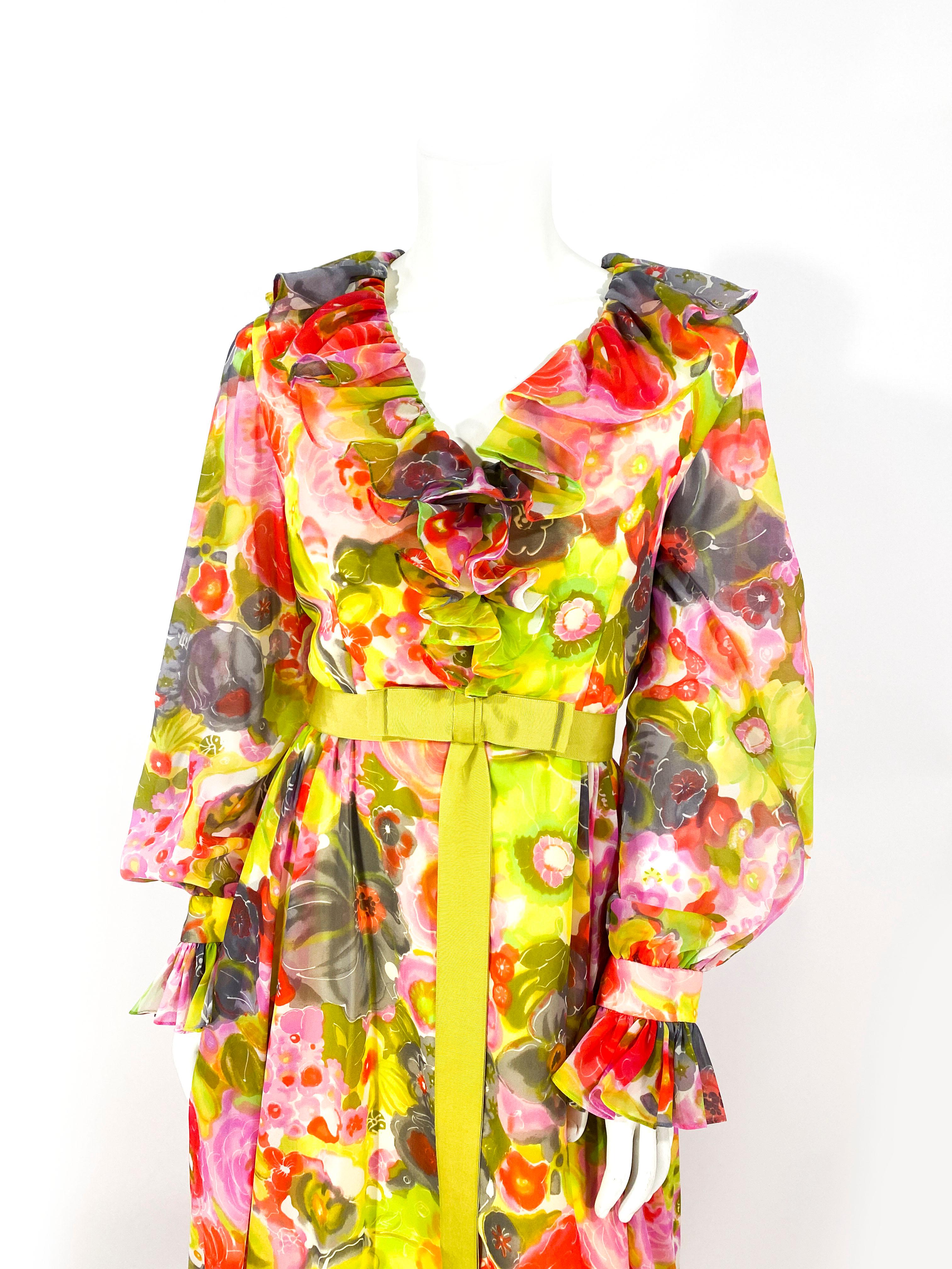1970s neon multicolored floral printed polyester chiffon dress featuring a full length skirt, deep ruffled v-neckline, matching chartreuse gros-grain waist bow accent, billowing sheer sleeves, and wide ruffled cuffs. 