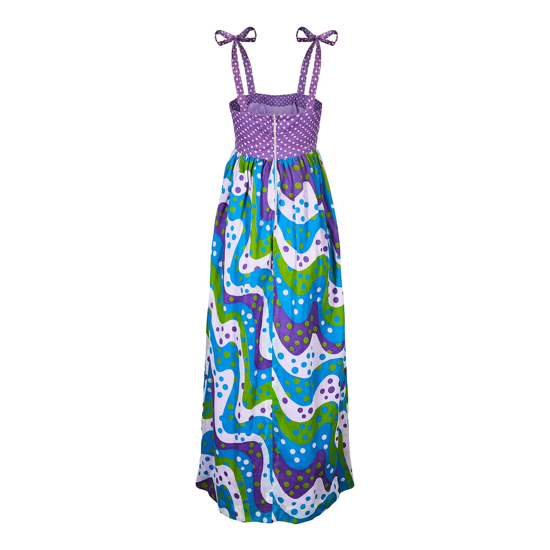 This original 1970s maxi dress combines two types of polka dot fabric in a bold format. The colour palette is a grassy green, teal, purple and white. The fabric is a starched lightweight muslin cotton with a very substantial quality brushed cotton