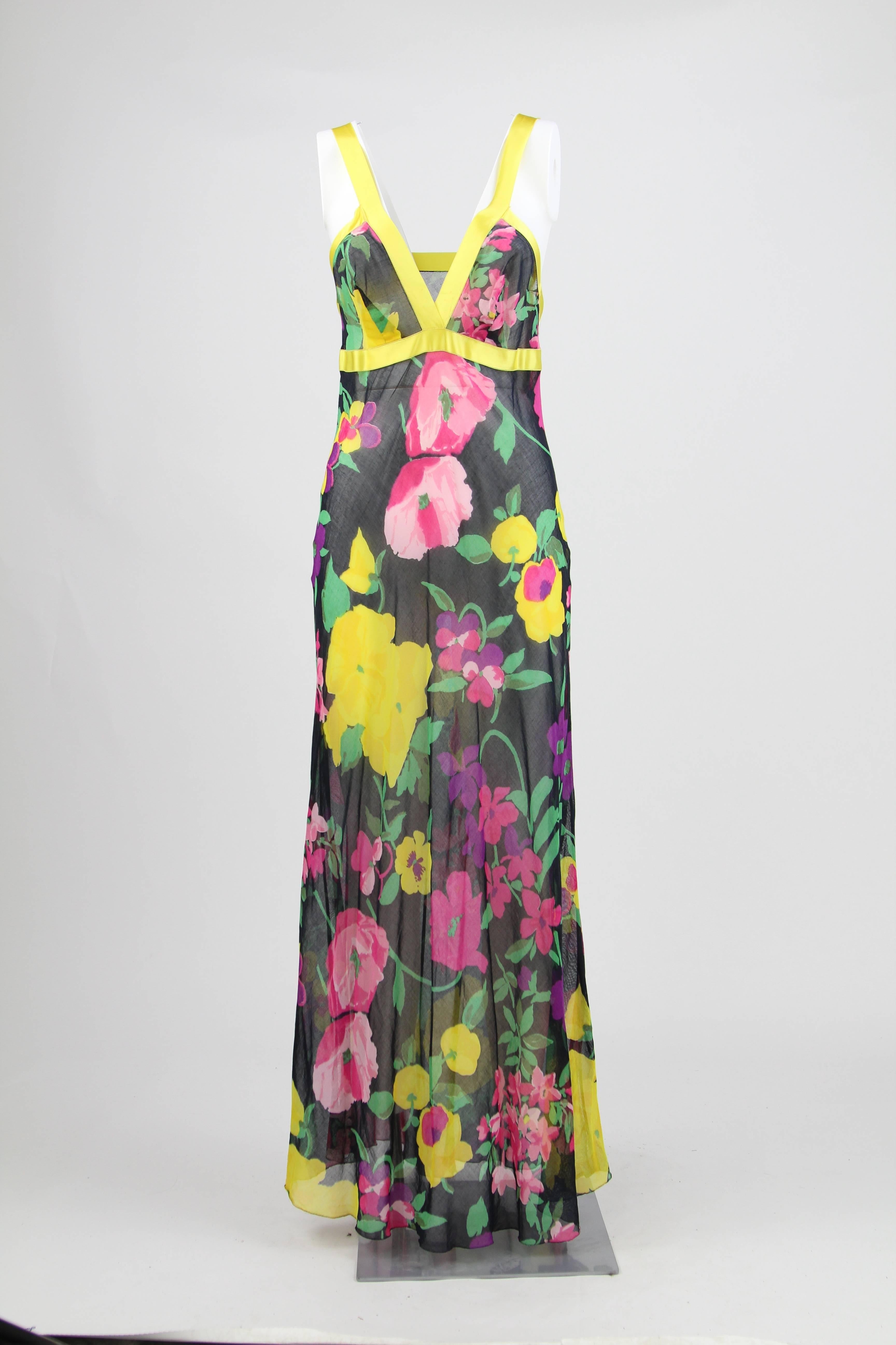 Delicate tailored sleeveless see-through dress in black color with a multicolor flower pattern and yellow silk hems. It features a high waist, underline by a silk band, and comes with a wrap-around sleeved surcoat with the same pattern. No fastens.