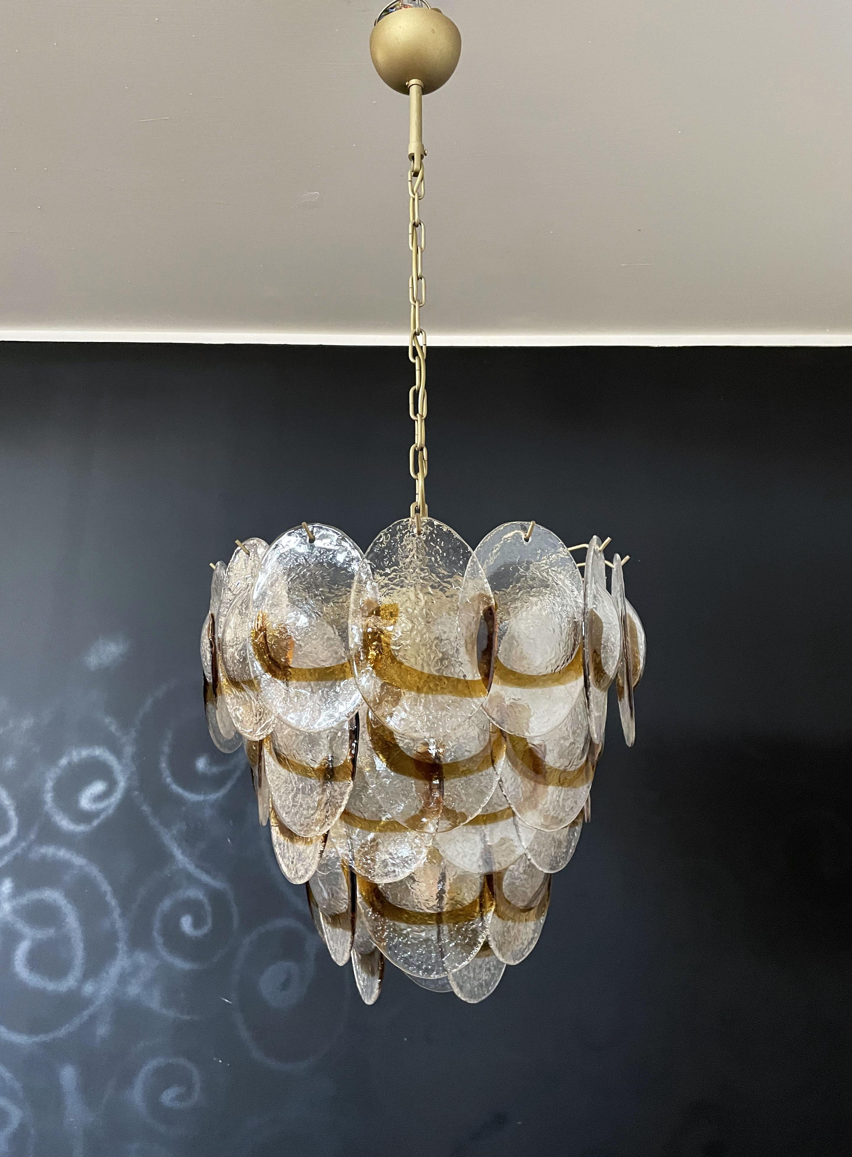 Italian vintage Murano chandelier made by 41 glass leaves in a gold painted metal frame. The originality of this chandelier is given by the glass, wonderful works of art trasparent and amber, called shells. Murano blown glass in a traditional