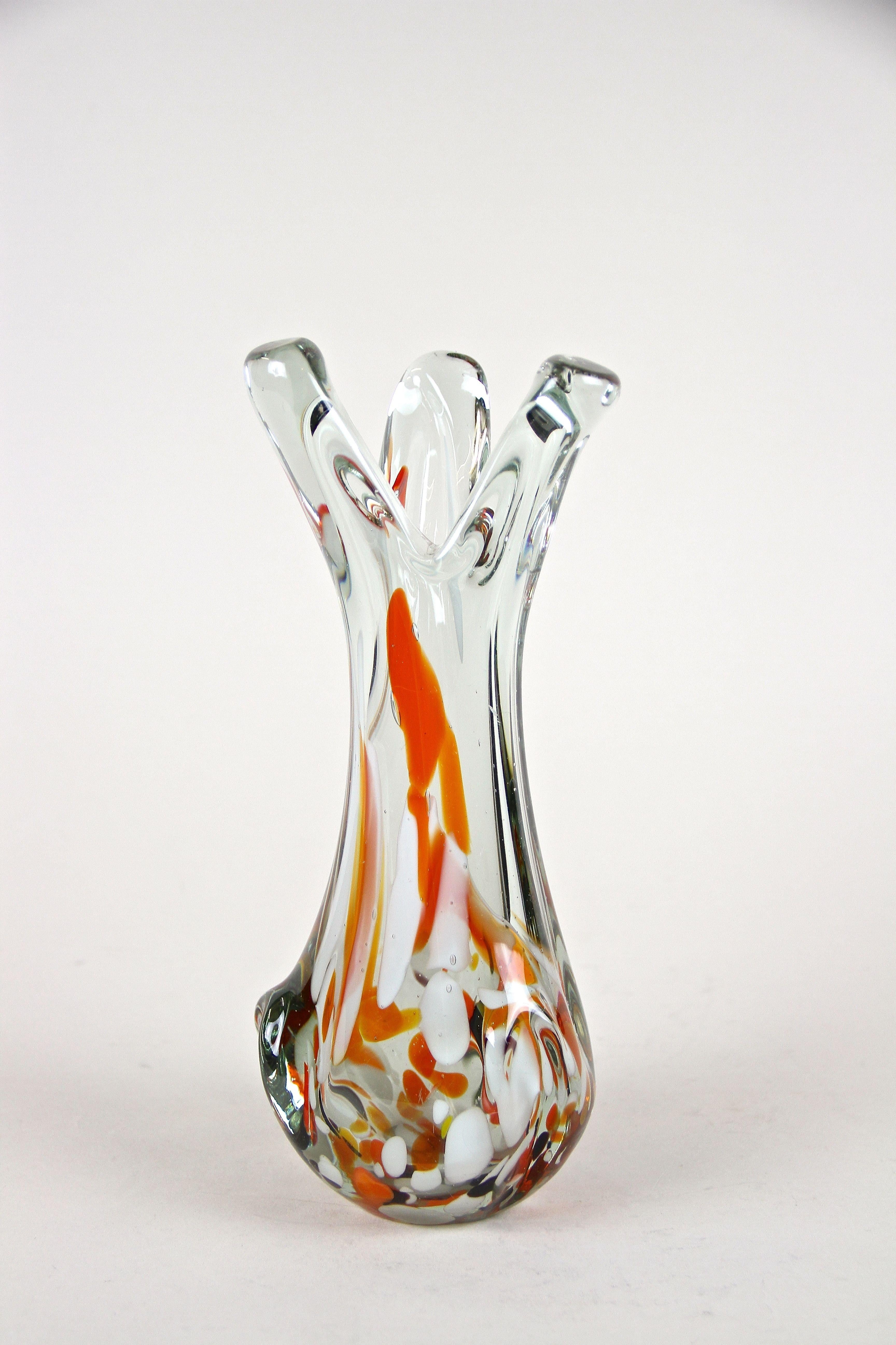 Lovely, unusual Murano glass vase made in the 1970s in Italy. The very decorative, clear glass vase comes with a beautiful shaped body showing fantastic looking melted spots in red, organge, brown and white tones. An extraordinary glass vase out of