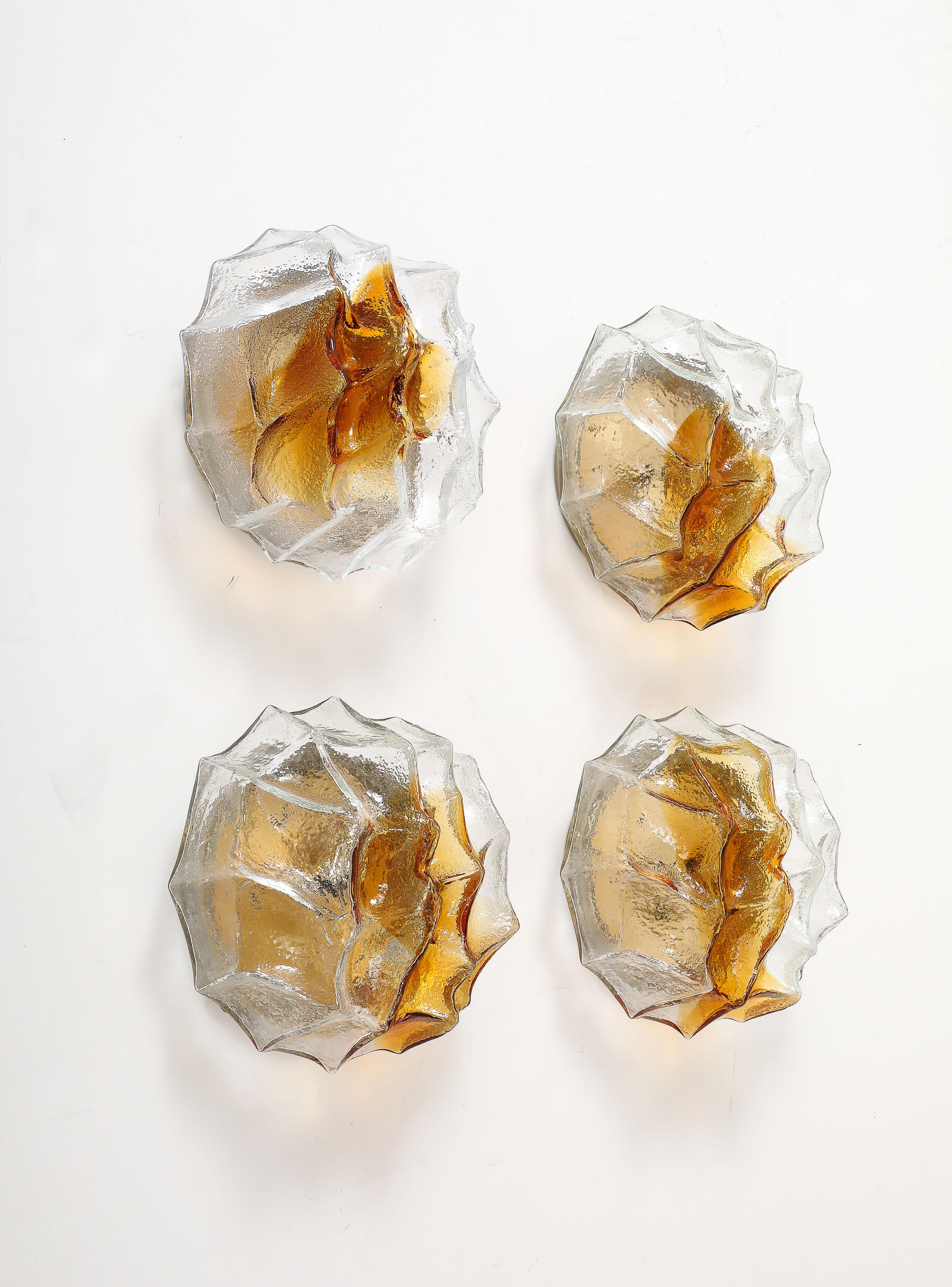 Pareja de apliques / empotrables de pared Iceberg de cristal de Murano de los años 70  de Carlo Nason para Mazzega.
Las formas facetadas de cristal transparente y ámbar Iceberg se asientan firmemente
en una placa trasera redonda que se ha recableado
