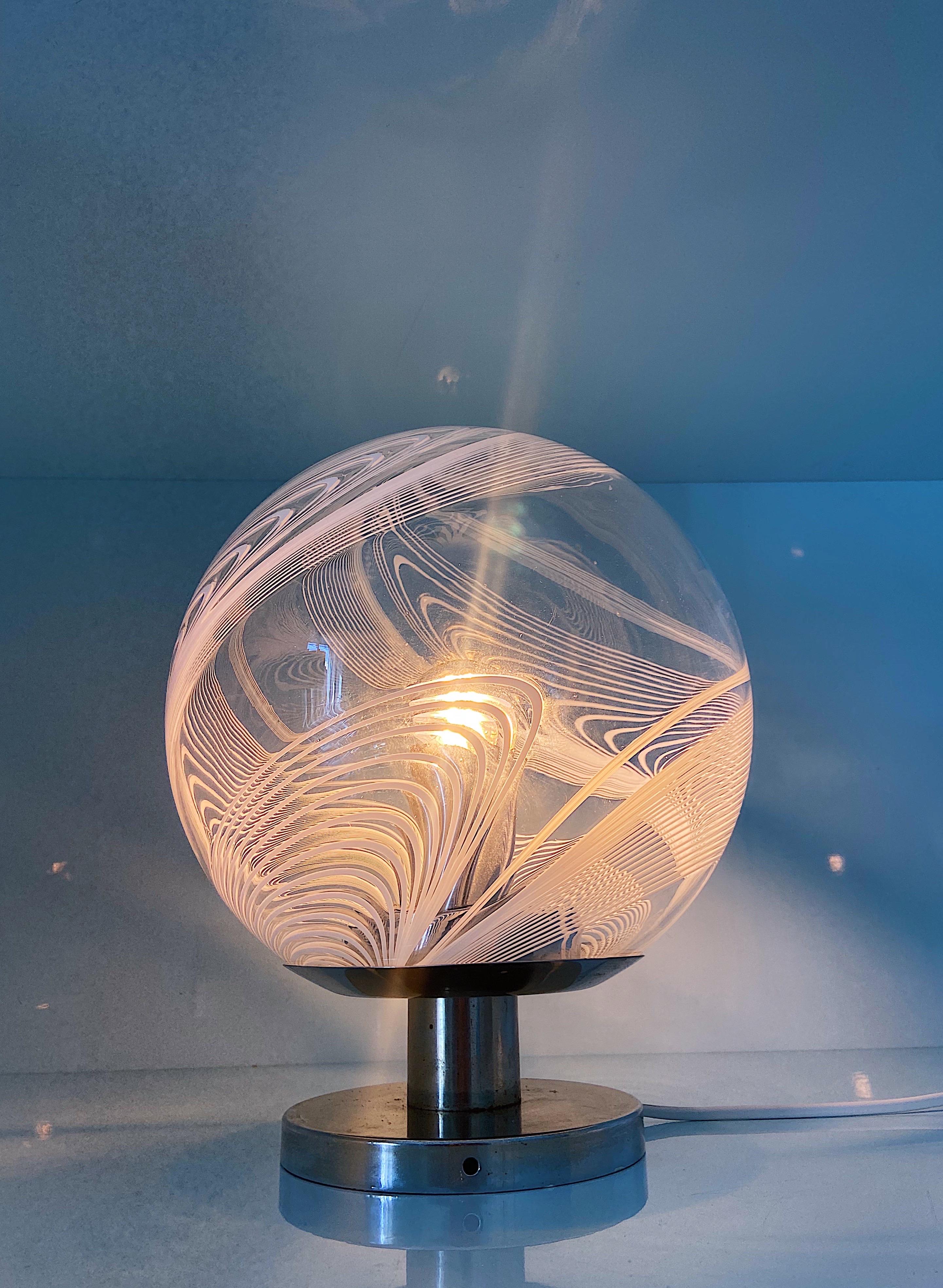 Stunning and rare Murano glass table lamp by Venini, 1970s.
The glass is transparent with a white irregular swirl decor.

Details
Creator: Venini, Murano
Dimensions: Height: 30 cm Width: 28 cm
Materials and Techniques: Glass, Metal
Place of
