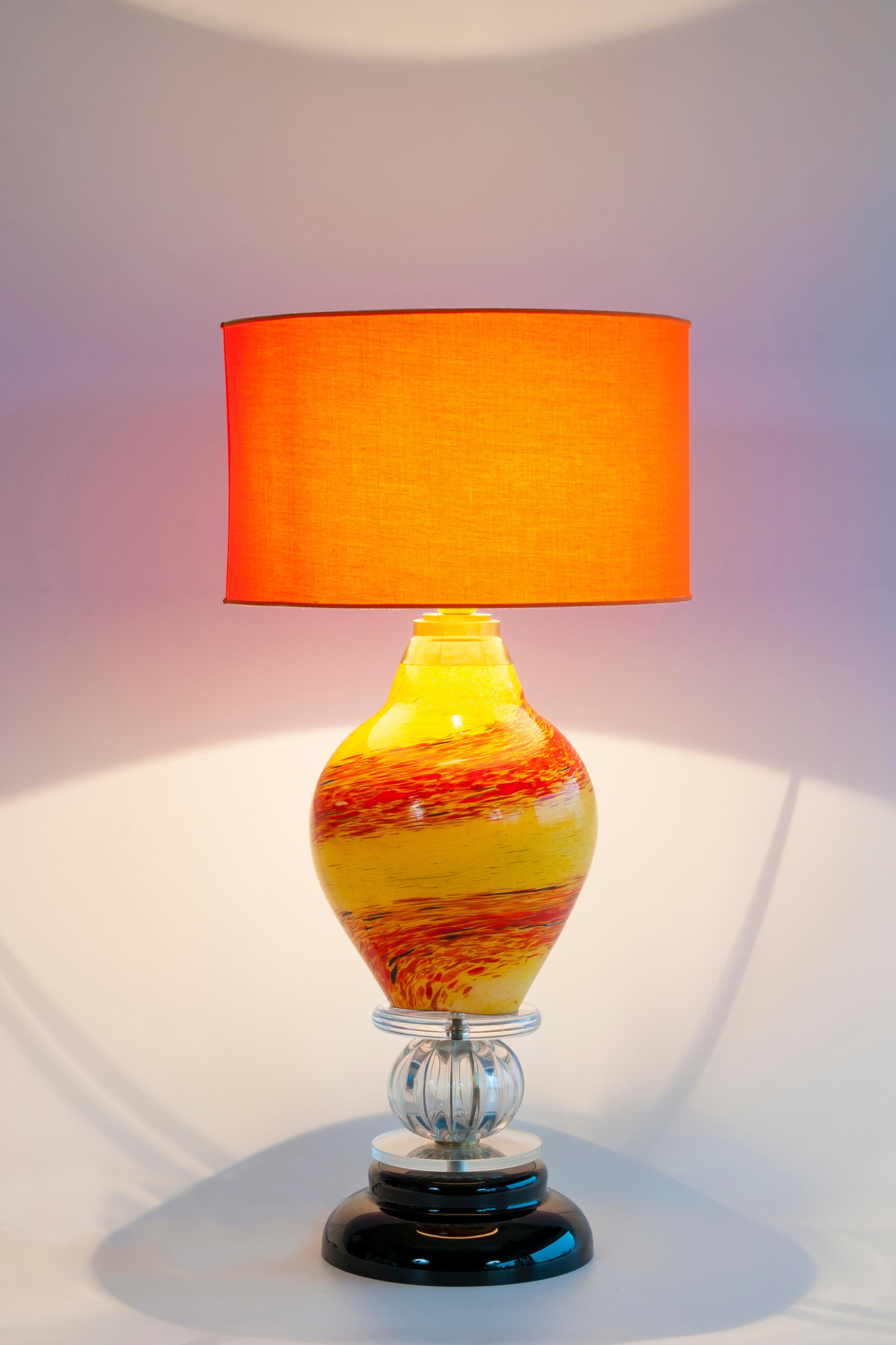 Le corps central de la lampe est une magnifique pièce de verre soufflée à la main, de forme curviligne et semblable à une goutte d'eau. Il présente un motif 