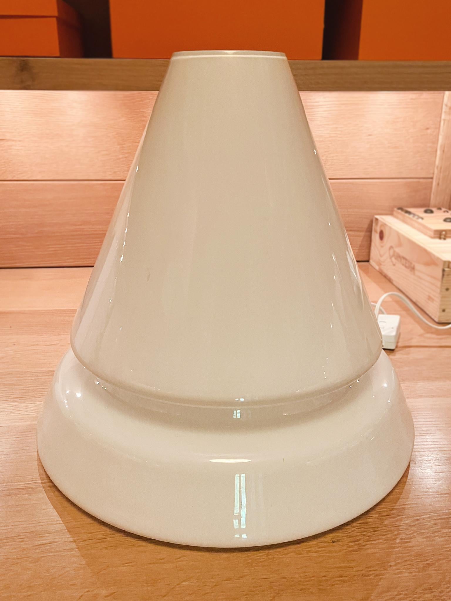 Esta lámpara de mesa cónica es de cristal de Murano y se fabricó en la década de 1970. Se ha recableado con un casquillo de una bombilla y se ha equipado con un regulador de intensidad. Cuando está encendida, la lámpara parece hecha de pura luz. Una