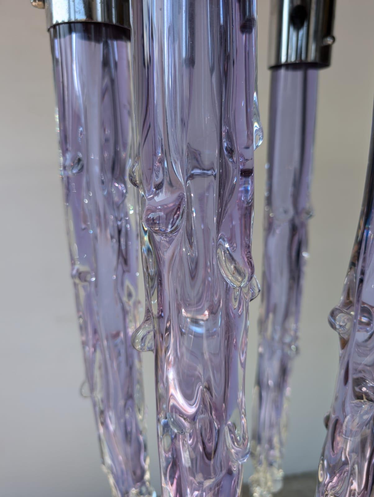 Sumerja su entorno en la vibrante elegancia de la lámpara de techo de cristal iridiscente de Murano de los años setenta. No es sólo un accesorio de iluminación, es un magnífico despliegue de creatividad y diseño artístico. Hecha a mano con cristal