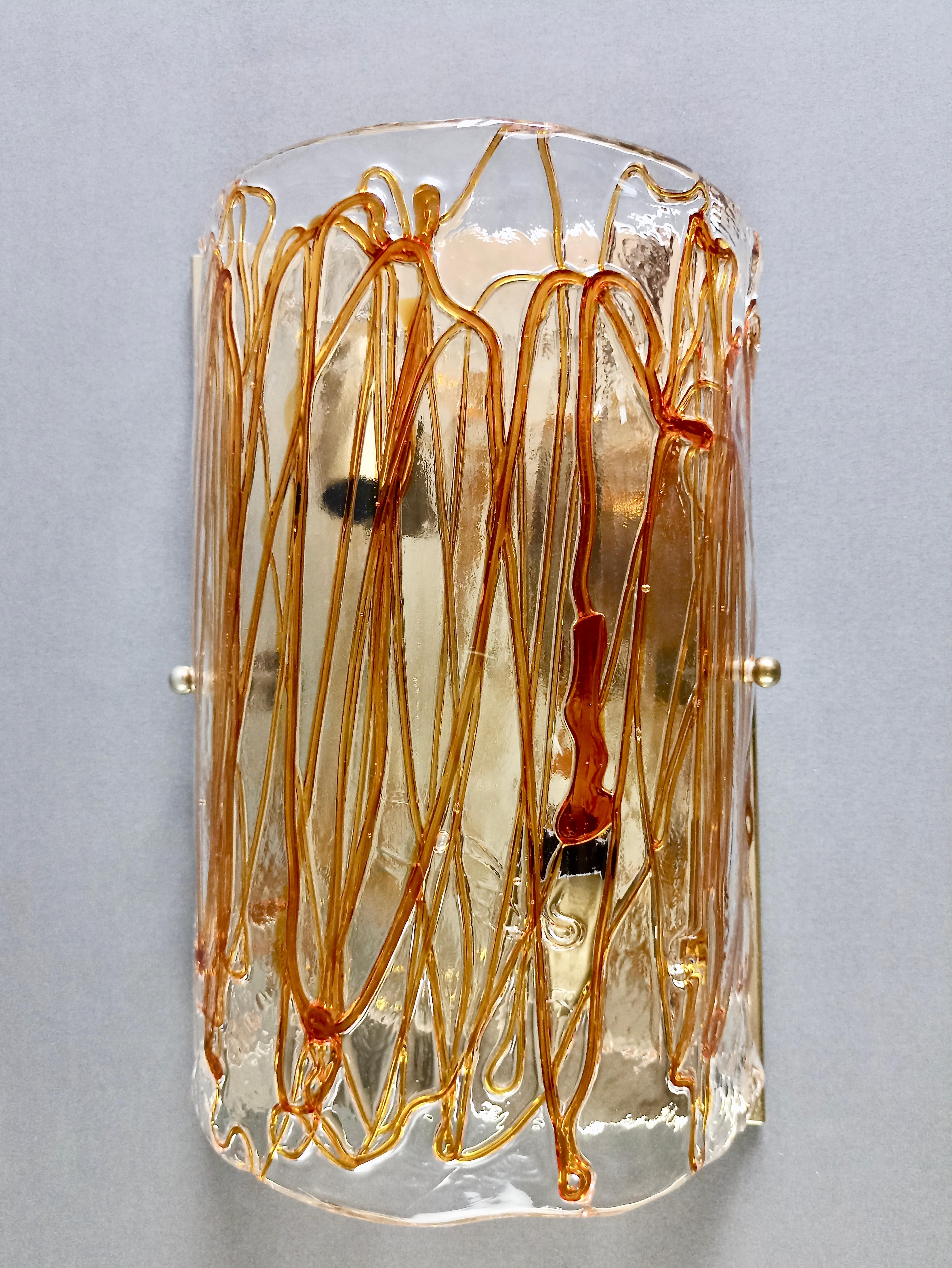 Beautiful original La Murrina Murano 1970s two-light sconce. 
The thick hand-blown transparent Murano glass lampshade has a semi-cylindrical shape and presents a very interesting effect due to the hot application of thin filaments of amber-colored