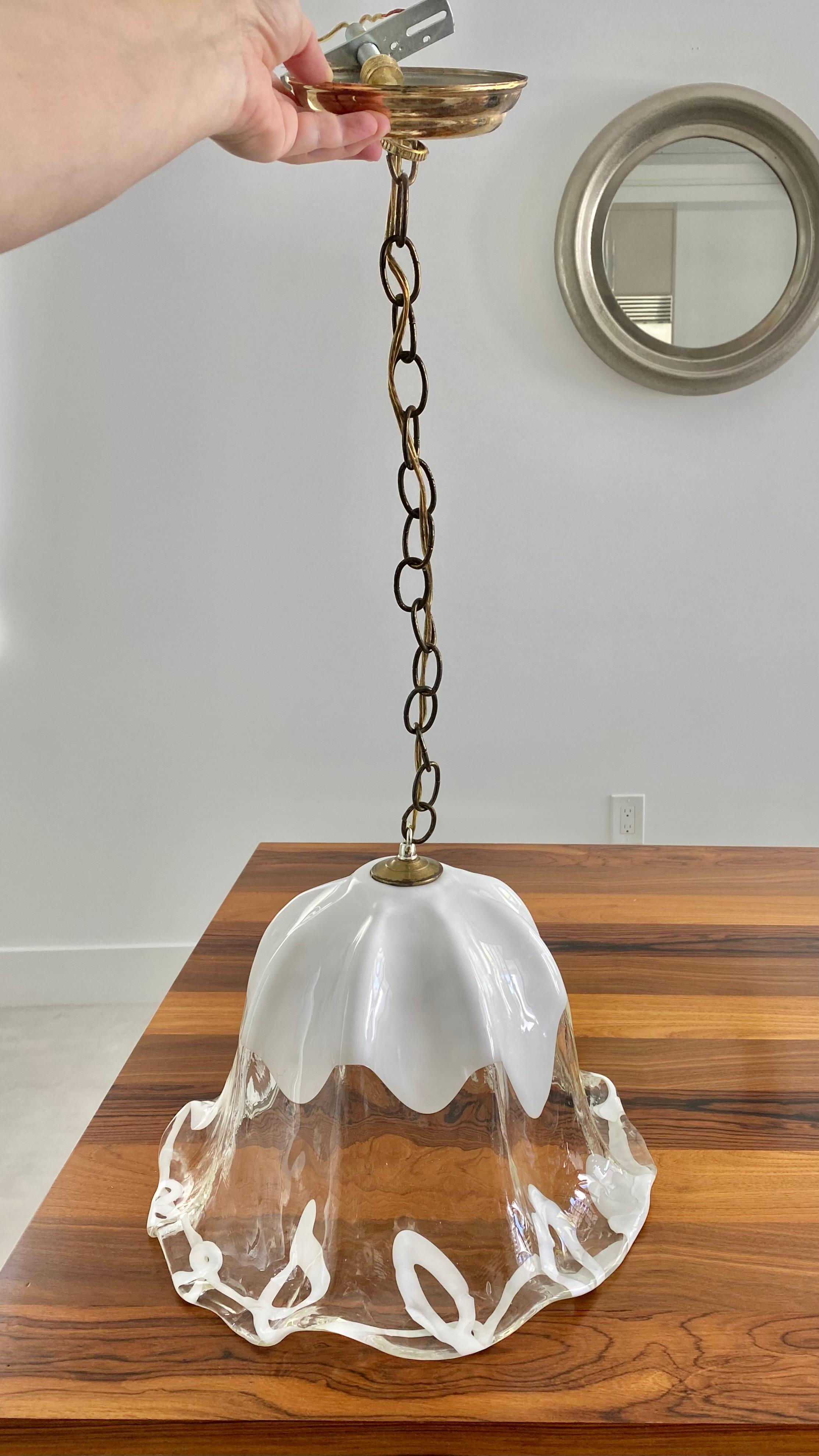 One of a kind, large transparent glass tulip pendant lamp in Italian Murano glass by famed maker AV Mazzega, circa 1970s.

Handmade piece with ribbons of white art glass that dance across the fluted edges of this substantial, yet delicate piece. The