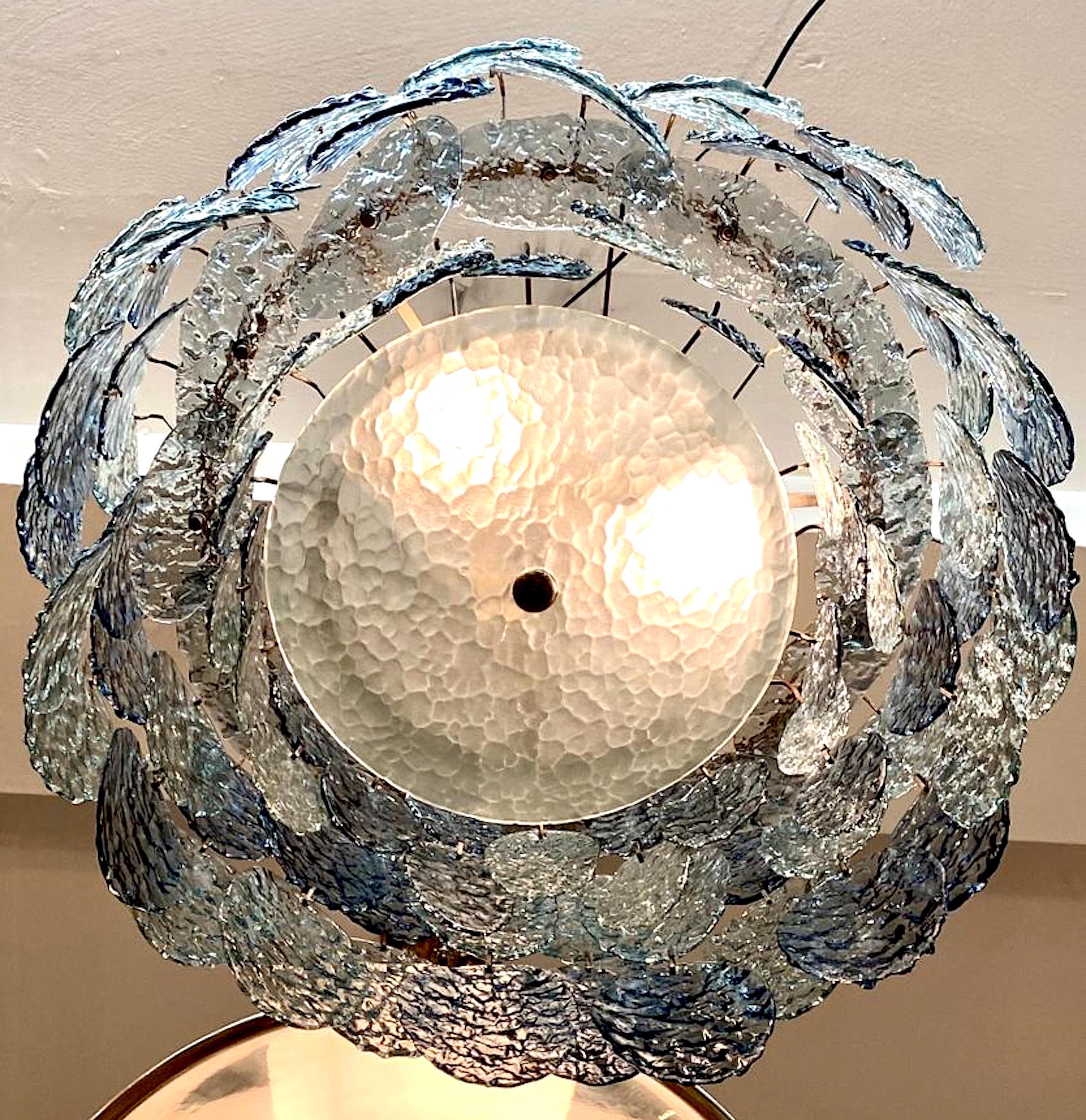 Magnifique lustre à disque en verre bleu foncé et fumé du début des années 1970, fabriqué à Murano, en Italie. Il a été conçu par le célèbre designer italien Gino Vistosi pour sa société d'éclairage Vistosi. Le lustre présente des disques ovales