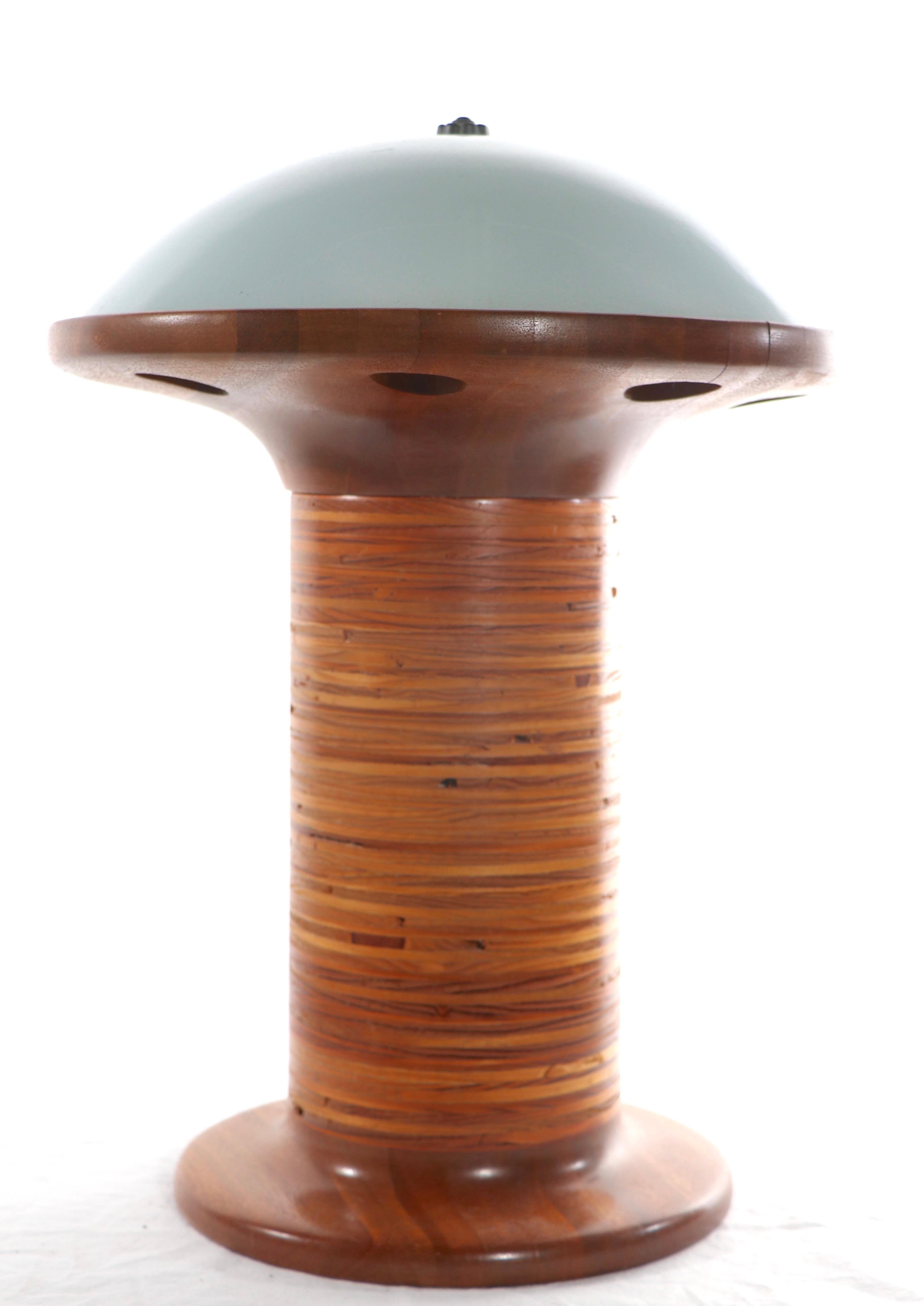 Unusual and possibly unique architectural design table lamp circa 1970's. The columnar base is constructed of stack wood disks, mounted on a solid turned wood base, with a space ship saucer like top, with glass top dome shade. The lamp is in