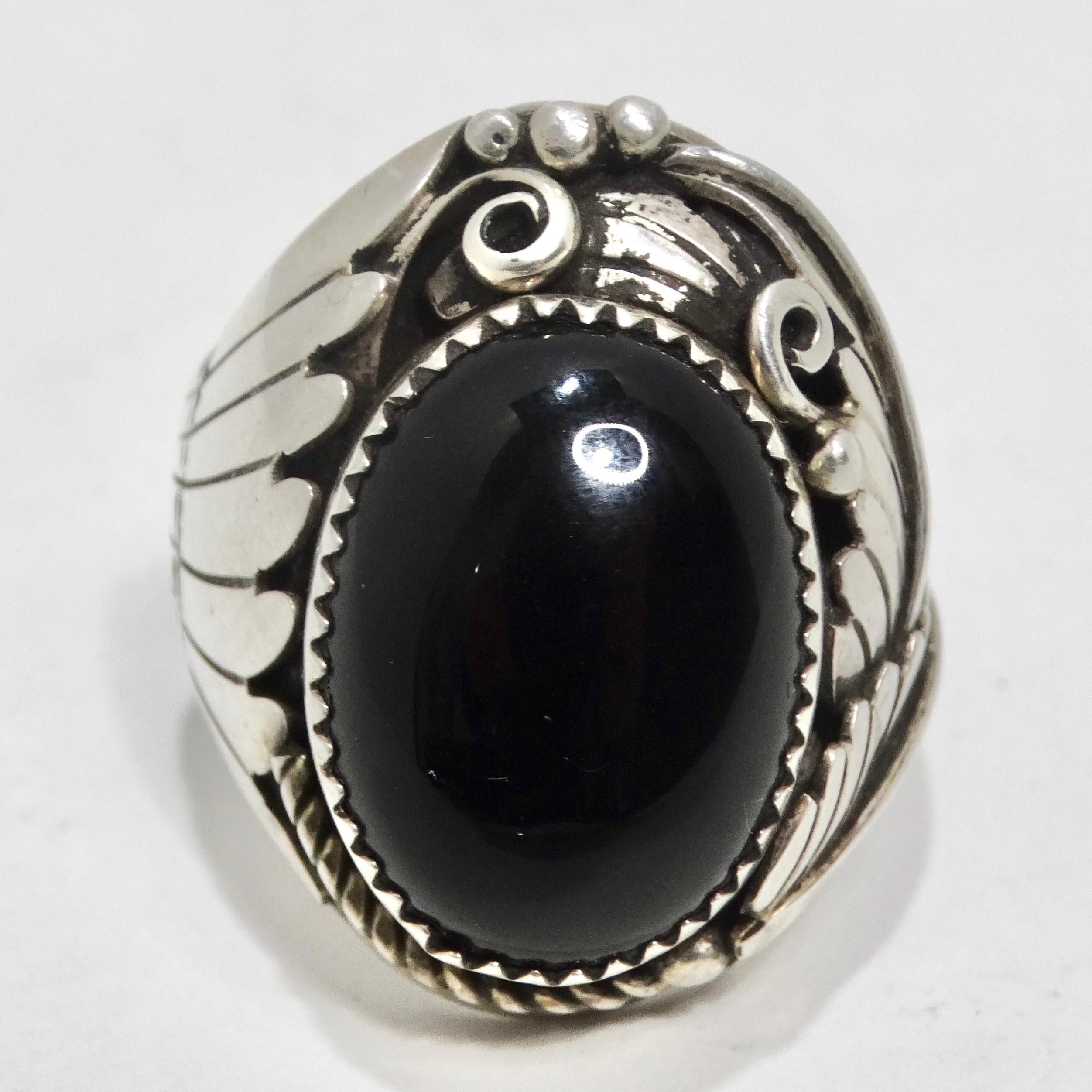 Voici la bague en argent et onyx des années 1970, une superbe bague de cocktail qui capture l'essence de l'élégance intemporelle et de l'artisanat amérindien. Cette bague n'est pas seulement un accessoire, c'est une œuvre d'art portable qui allie