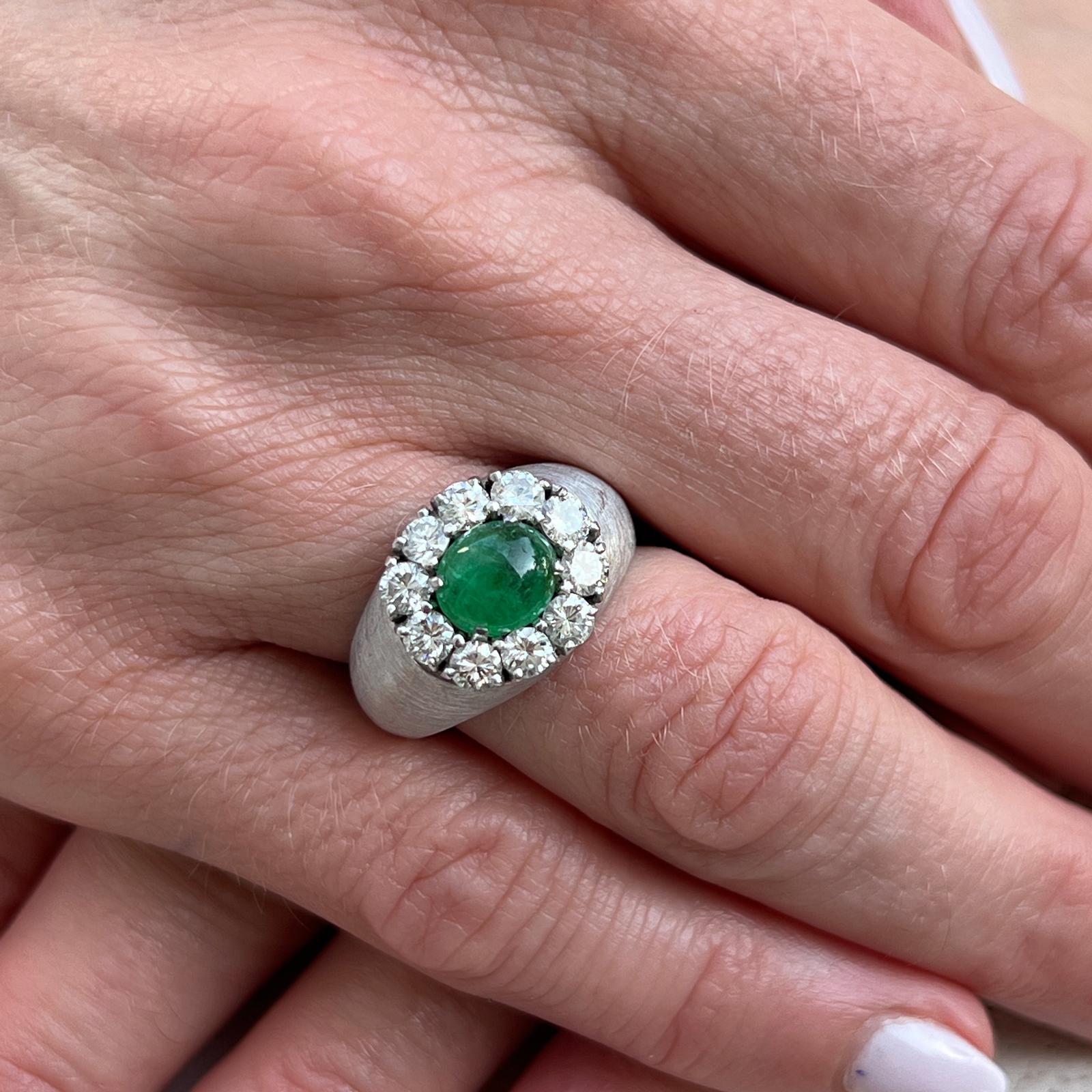 Diamond and emerald cocktail ring crafted in satin finish 14 karat white gold. The cabochon natural emerald weighs 1.12 carats. Ten round brilliant cut diamonds weigh approximately 1.40 carat total weight and are graded F-G color and VS clarity. The