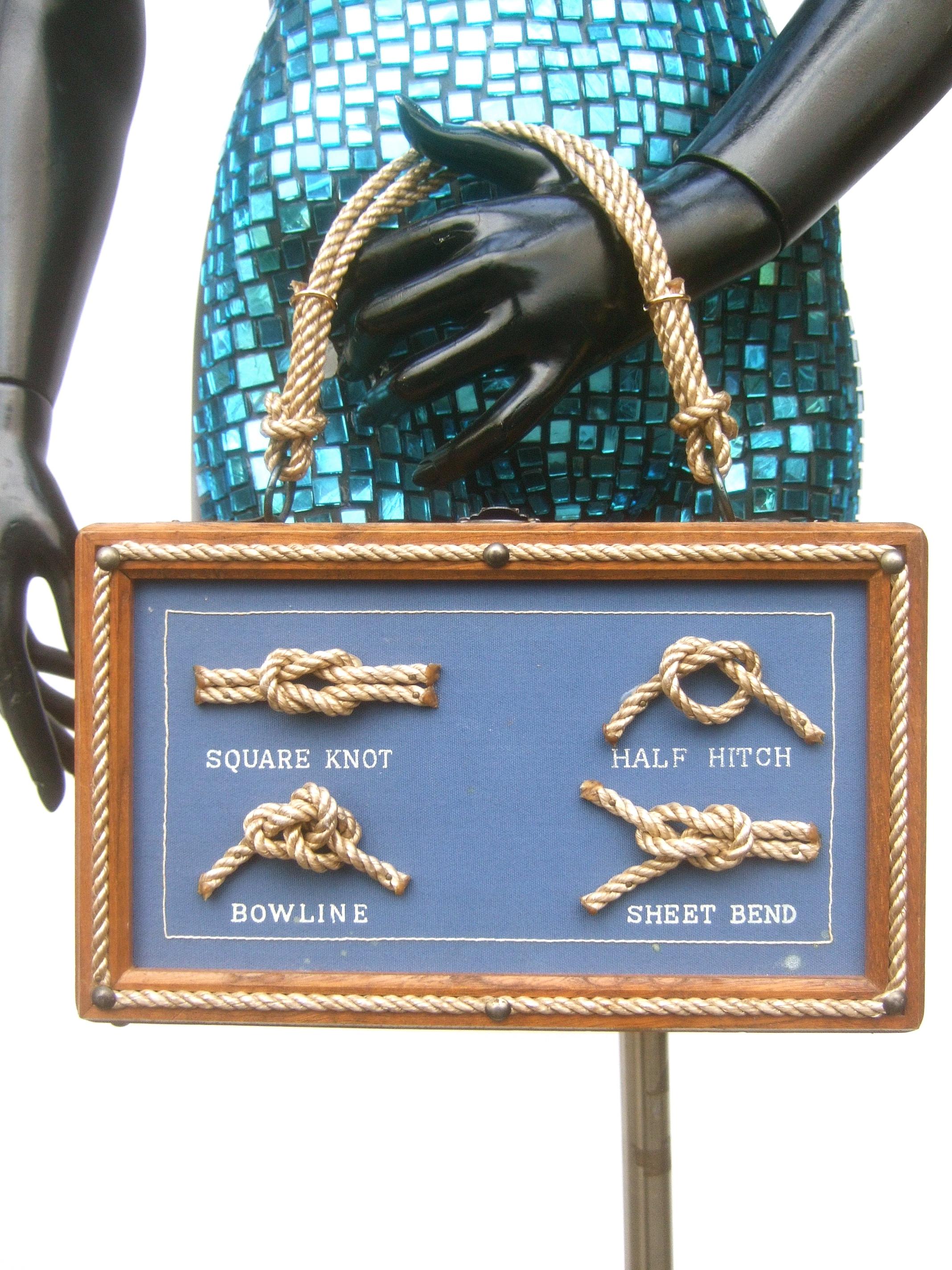 1970's Whimsical nautical rope wood box purse 
The quirky retro wood box purse is designed with four types
of rope knots on the front exterior; a square knot, half hitch, bowline & sheet bend; set against a blue background
Framed with a rope border.