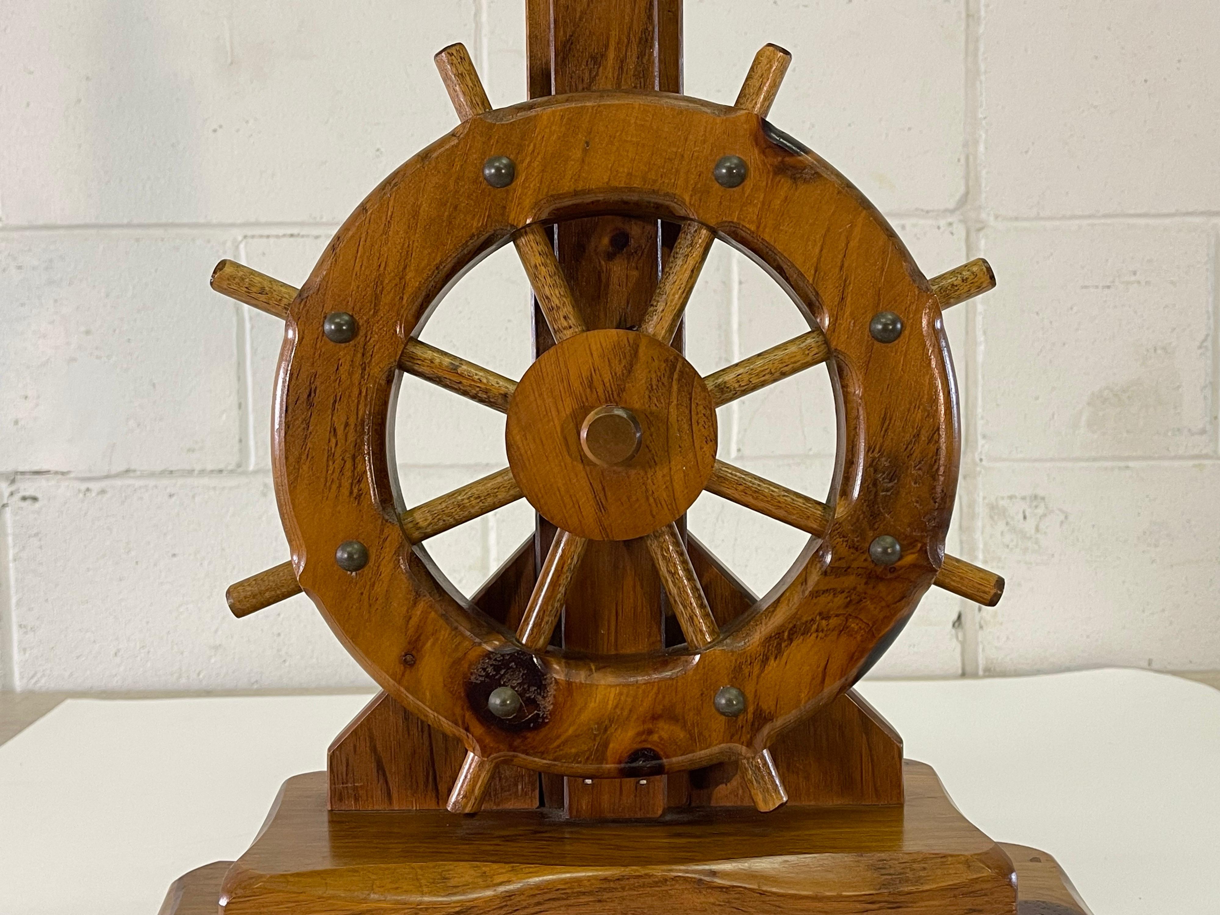 Vintage 1970s nautical ships wheel pine wood table lamp with a rope accented base. Wired for the US and in working condition. No marks.