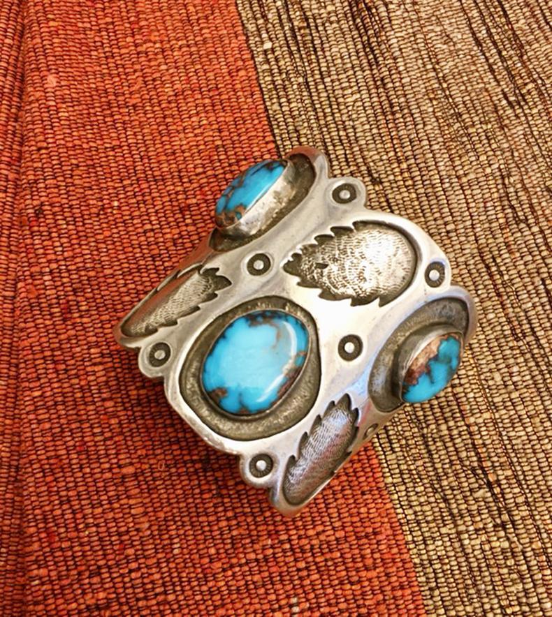 A large Navajo sterling silver cuff with leaf motif stampwork and three large top-grade Bisbee turquoise stones, circa 1970.

The circumference of the bracelet is 5.75