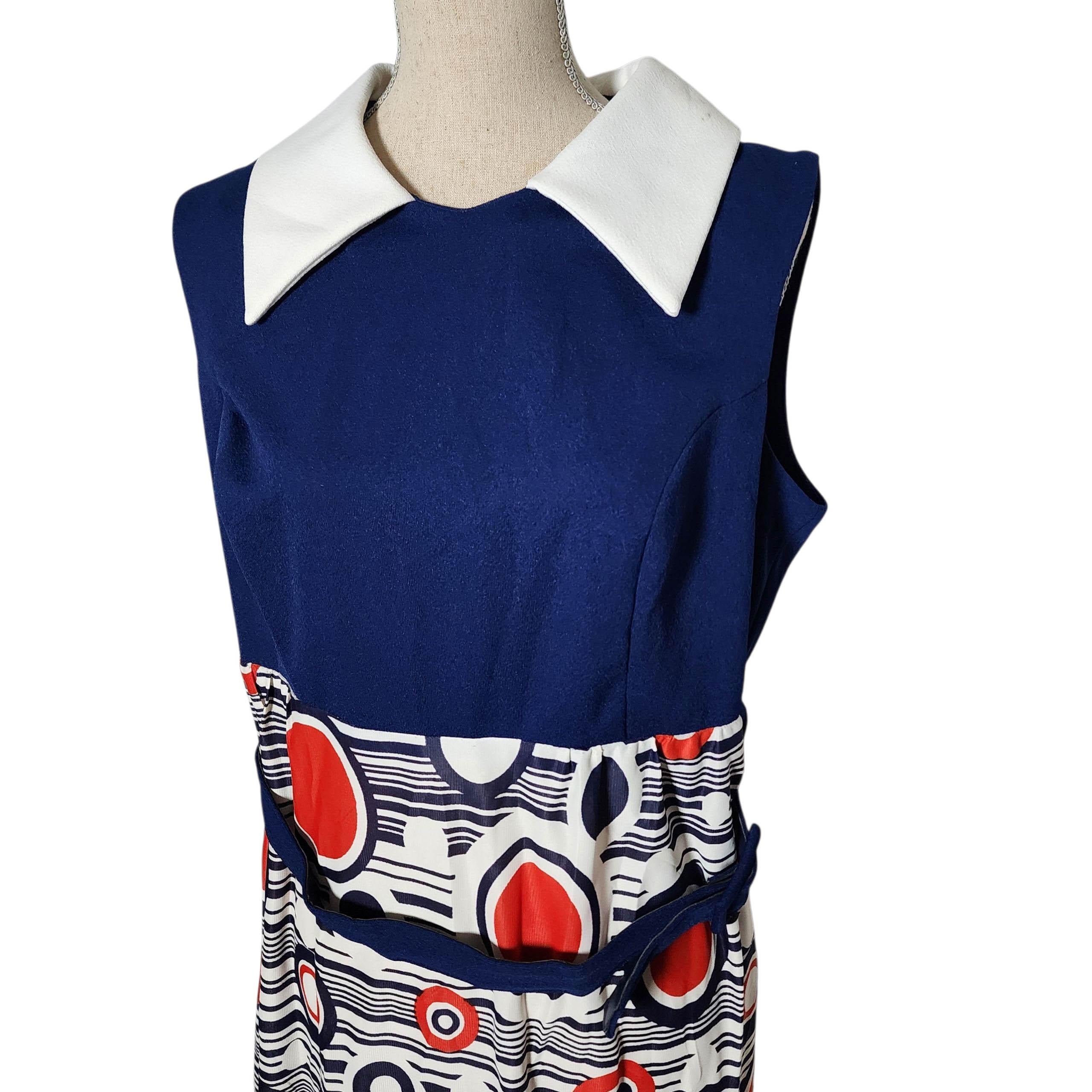 Cette robe sans manches des années 1970, qui attire l'attention, associe un tailleur impeccable à une esthétique moderne audacieuse. Dotée d'un corsage structuré bleu marine et d'une jupe à imprimé géométrique rouge, blanc et bleu, cette pièce est