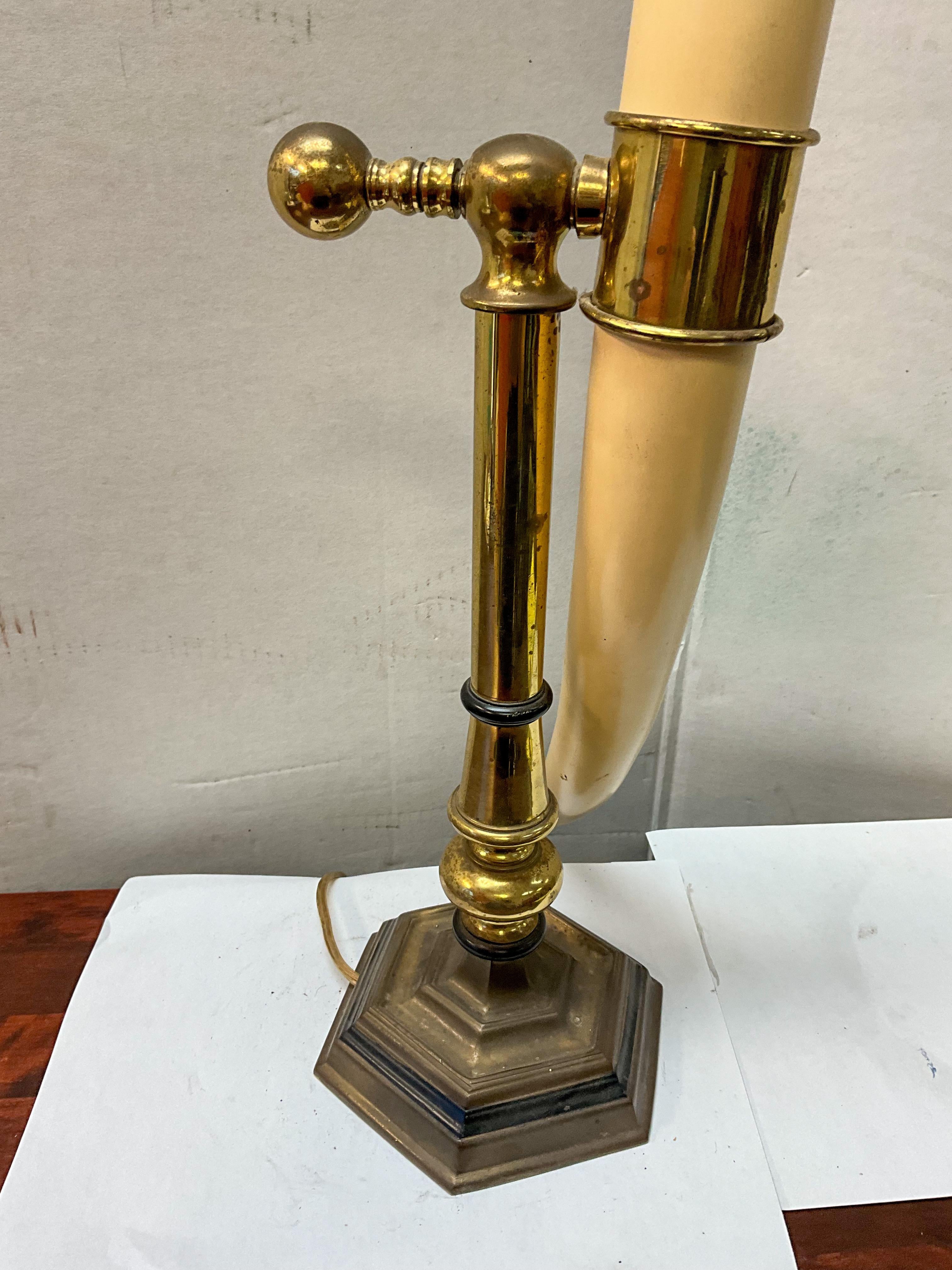 This is a neoclassical style desk or table lamp that is a faux horn mounted to a brass support. It is adjustable by the knob in the back. It is by Chapman. There is wear to the brass.