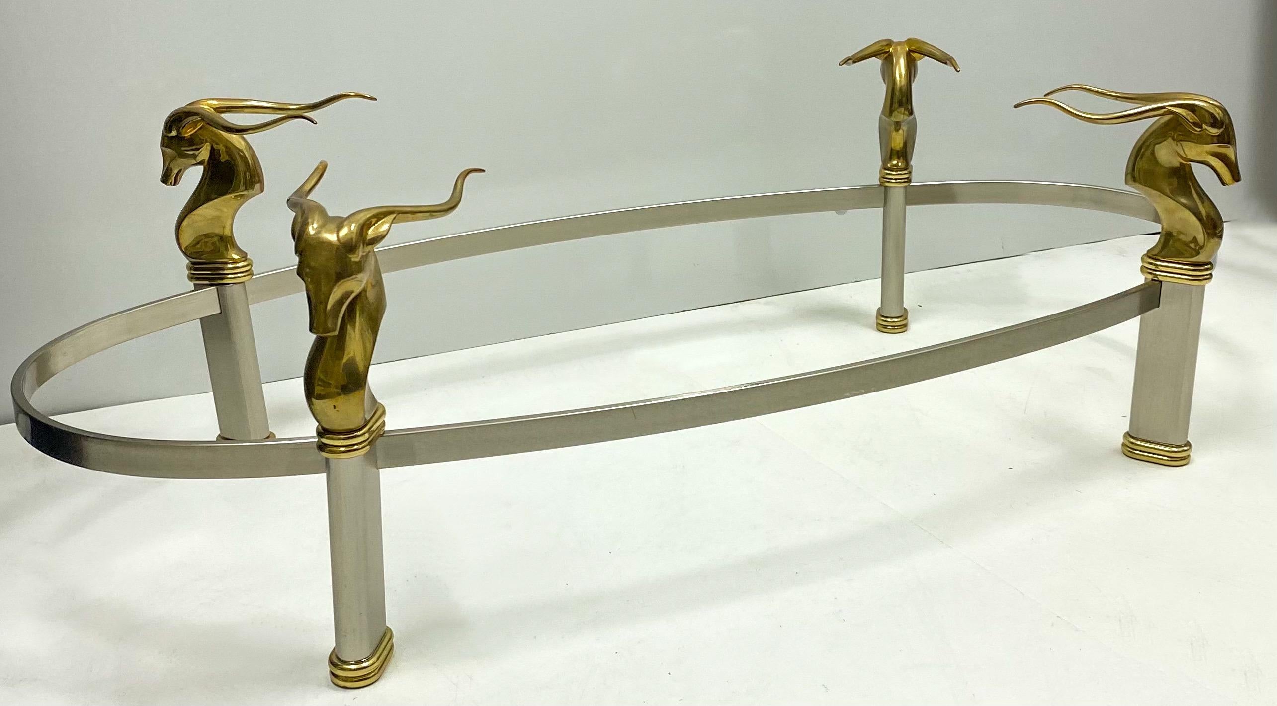 This is a modern interpretation of neoclassical styling with a sleek blend of brushed steel and brass and glass. The four supports are brass gazelles. The gazelles are connected by brush steel. This piece is unmarked and most likely dates to the