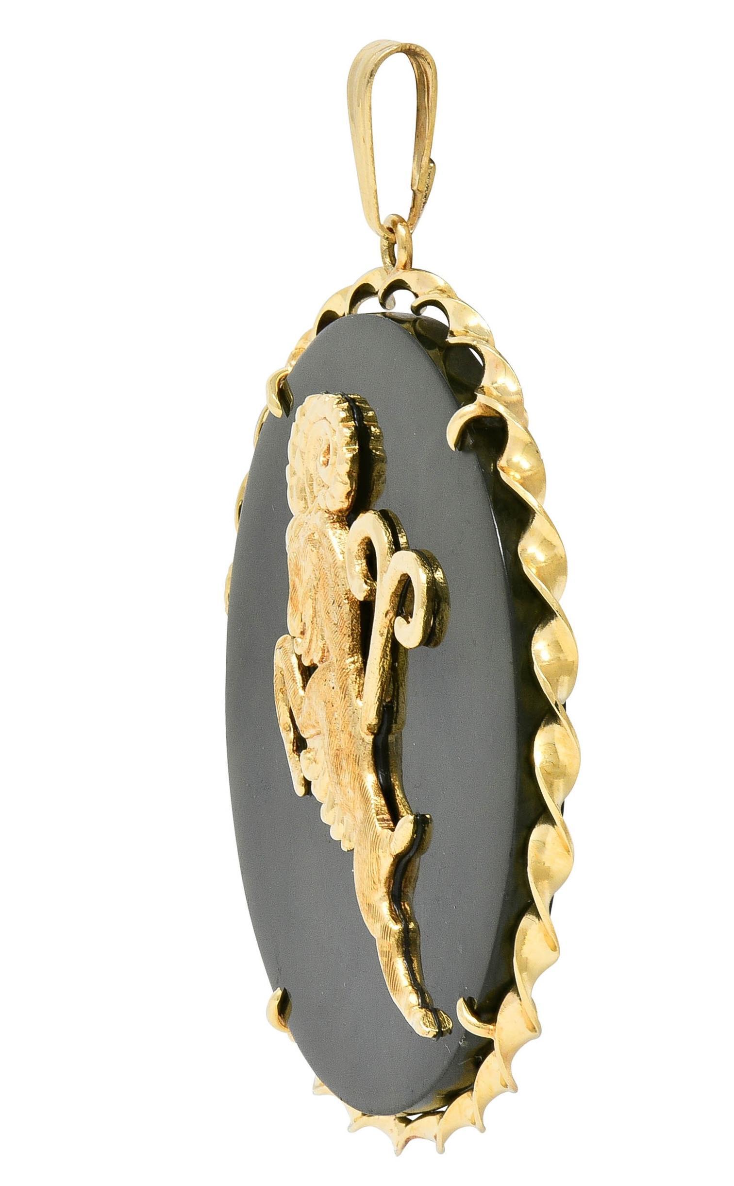 Designed as a round twisted wire disk centering a nephrite jade tablet
Translucent dark mossy green with black mottling throughout
Measuring 45.0 mm round - centering a rearing ram
With grooved detail and engraved fur texture
Shown with Aries